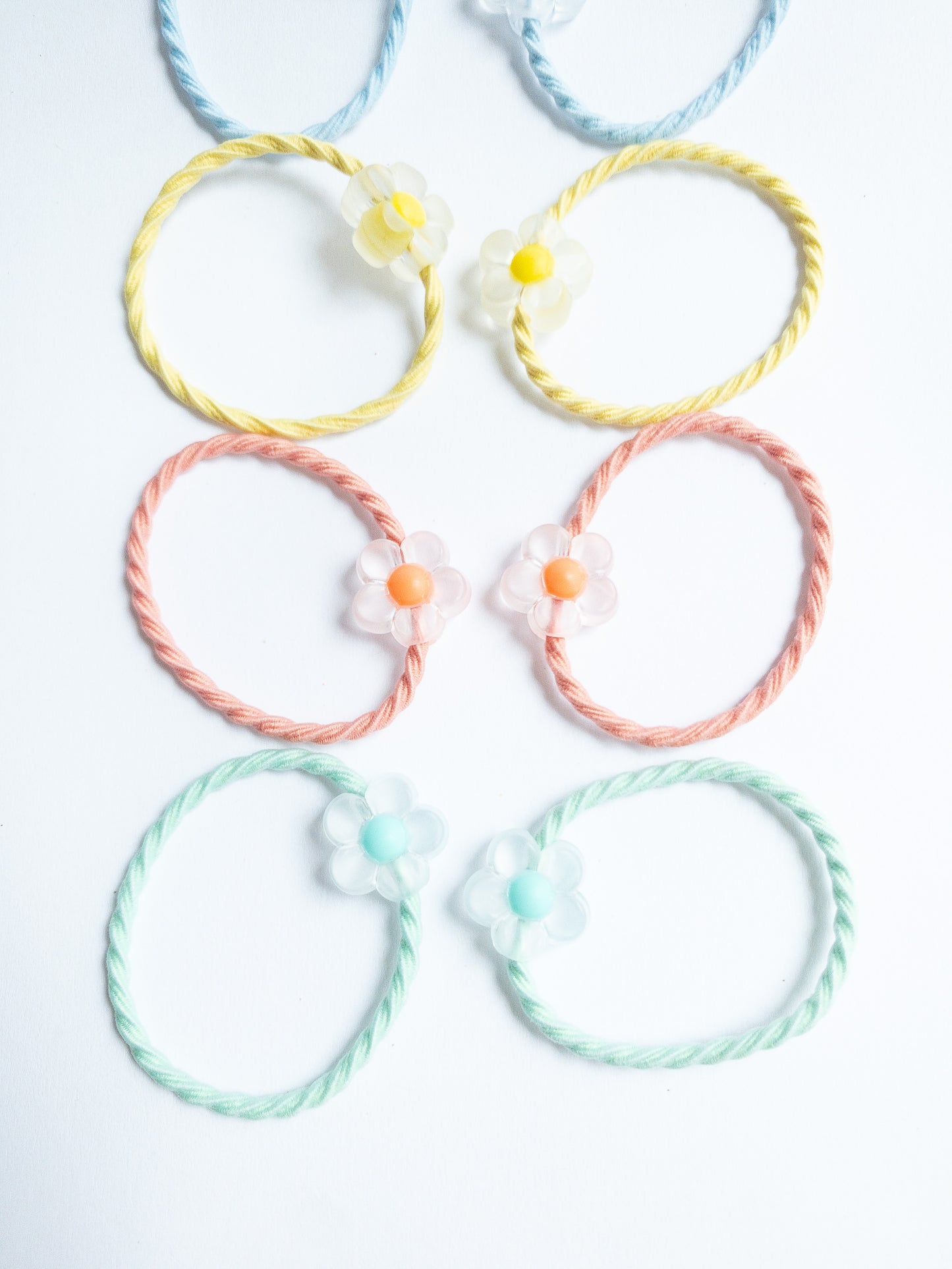 Cute little milky yogurt flowers on fabric soft hair ties. Each set contains 10 hair ties.