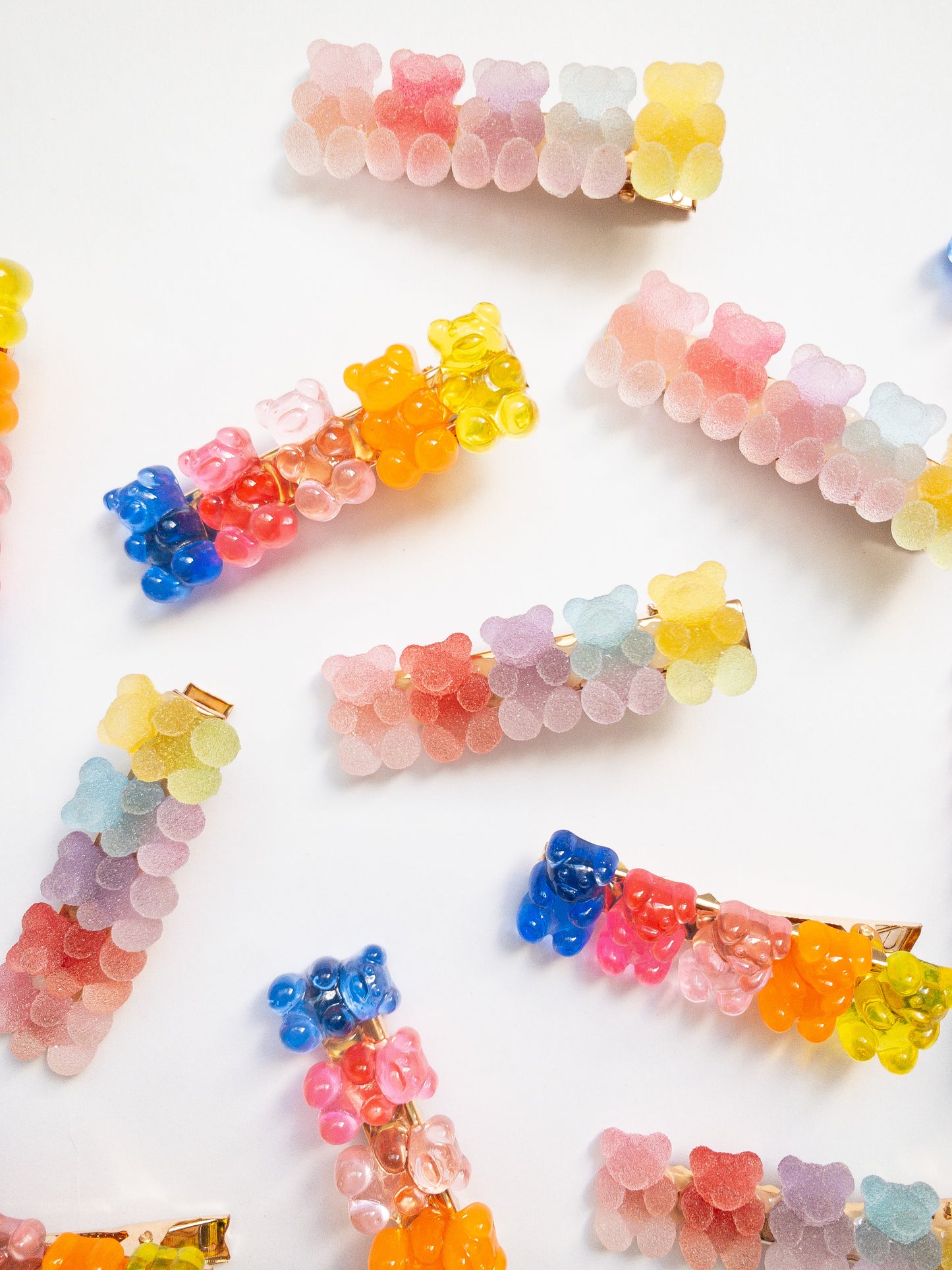 Yummy gummy bear family! The most adorable gummy bear shaped hair clips come as a 4 piece set: two frosted, sugary gummy bears and two translucent rainbow colored gummy bears. Each is on a gold colored alligator clip.