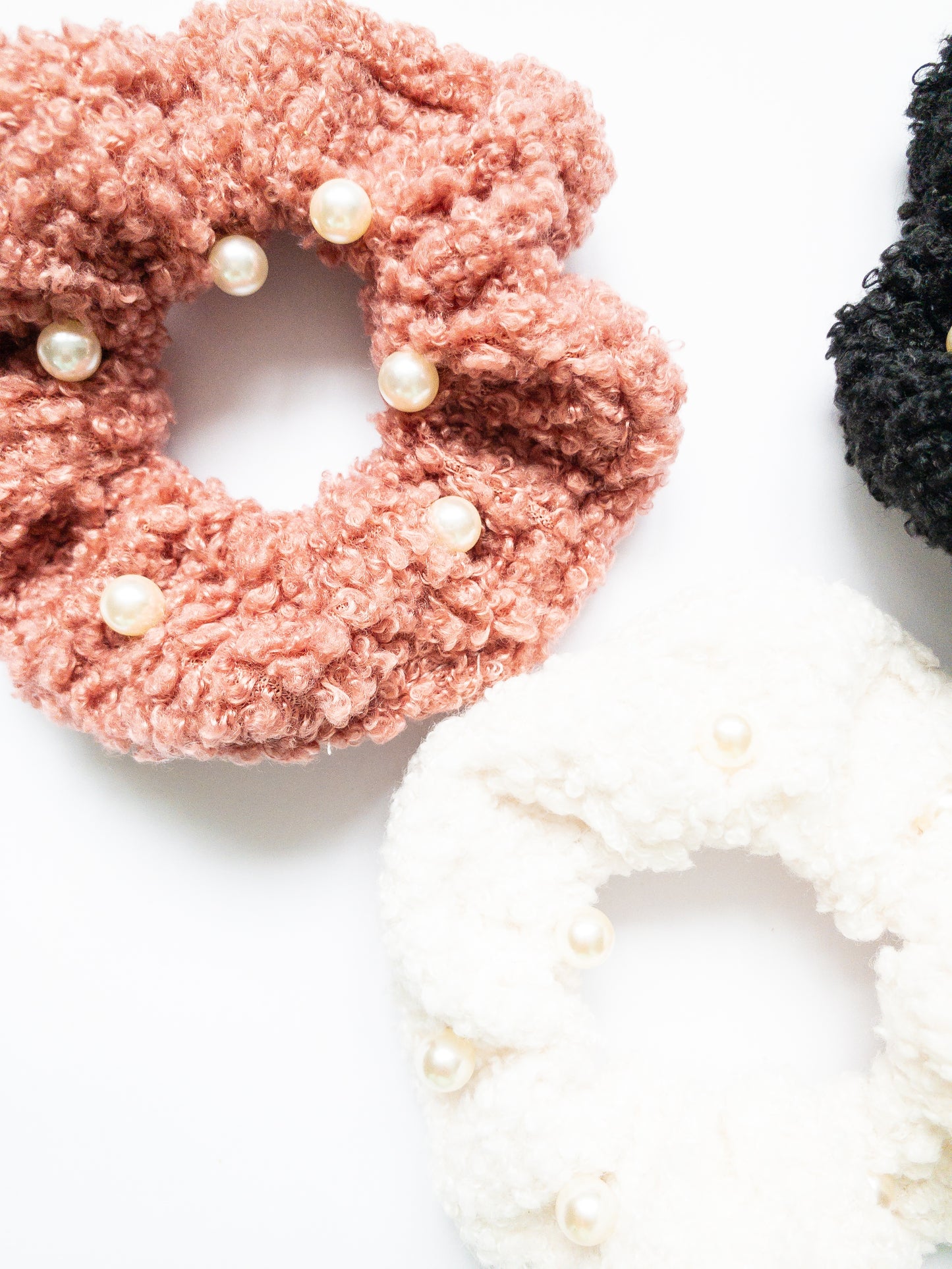 These peppy pearl sherpa scrunchies are so soft and comfy chic! A 3-pack mix of pink, black, and white sherpa and pearls sewn throughout.