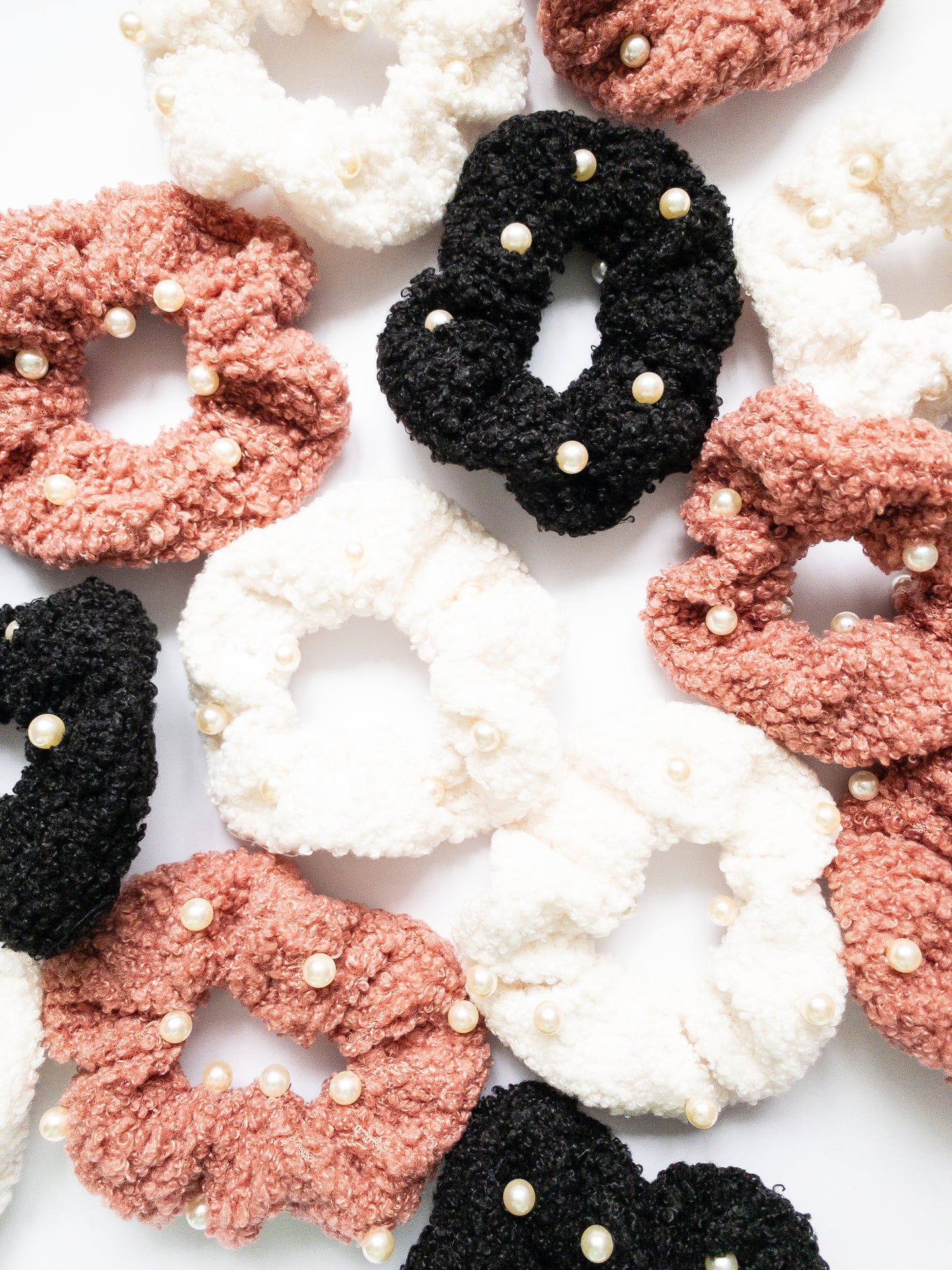 These peppy pearl sherpa scrunchies are so soft and comfy chic! A 3-pack mix of pink, black, and white sherpa and pearls sewn throughout.