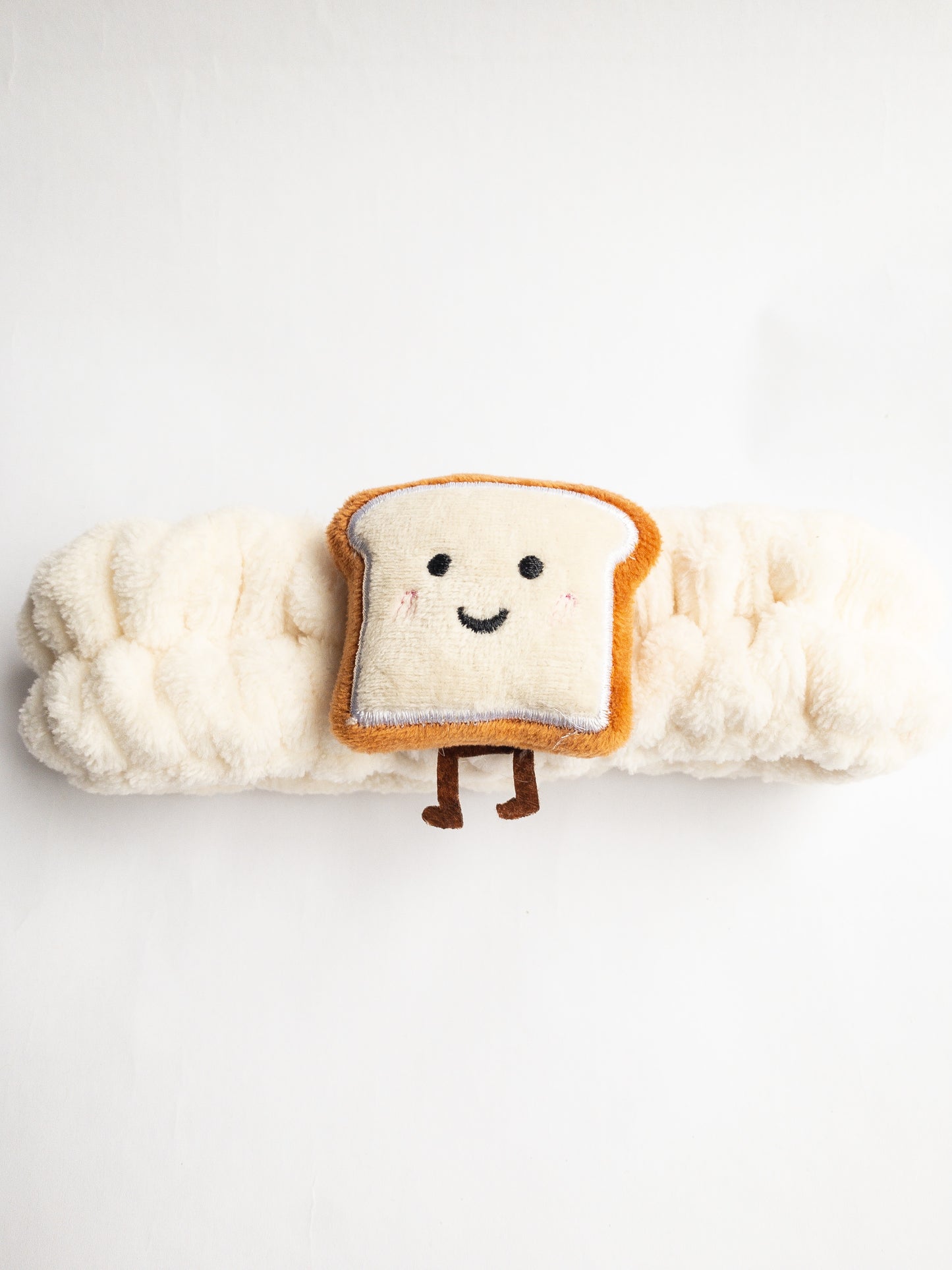 Our adorable brick toast plush spa headband makes the perfect accessory for all your spa days! Each headband is so soft and comfy with a cute and happy little brick toast. Pamper yourself in plushy-goodness and sweet, sweet relaxation! Go ahead, you deserve it!