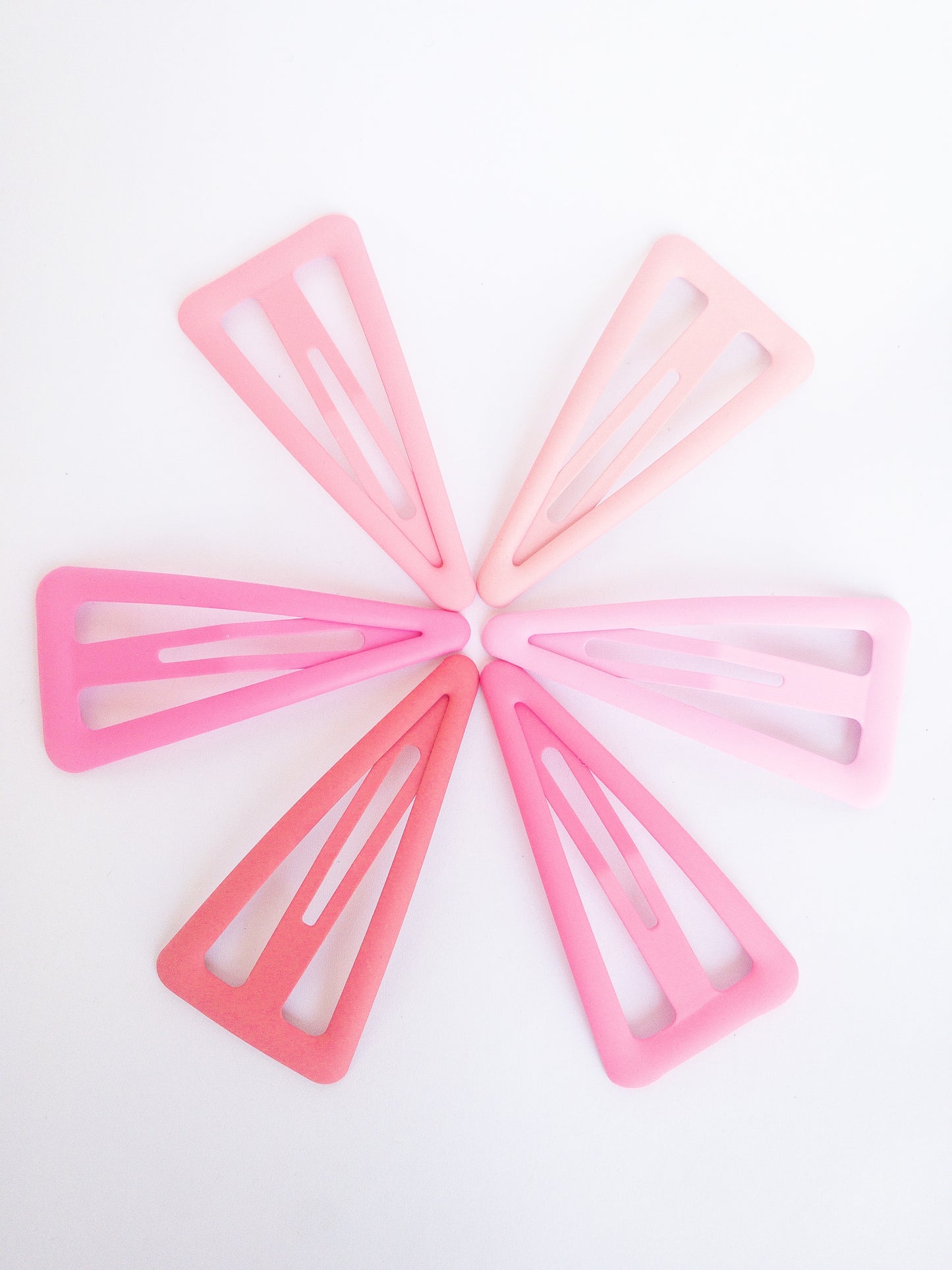 These large triangle snap clips are a fan favorite! With an ombre color palette fading from darker to lighter shades, you can mix them up and wear them together or choose your favorite of the day. Larger than your usual snap clip, these are sure to make a statement and hold your hair firm.