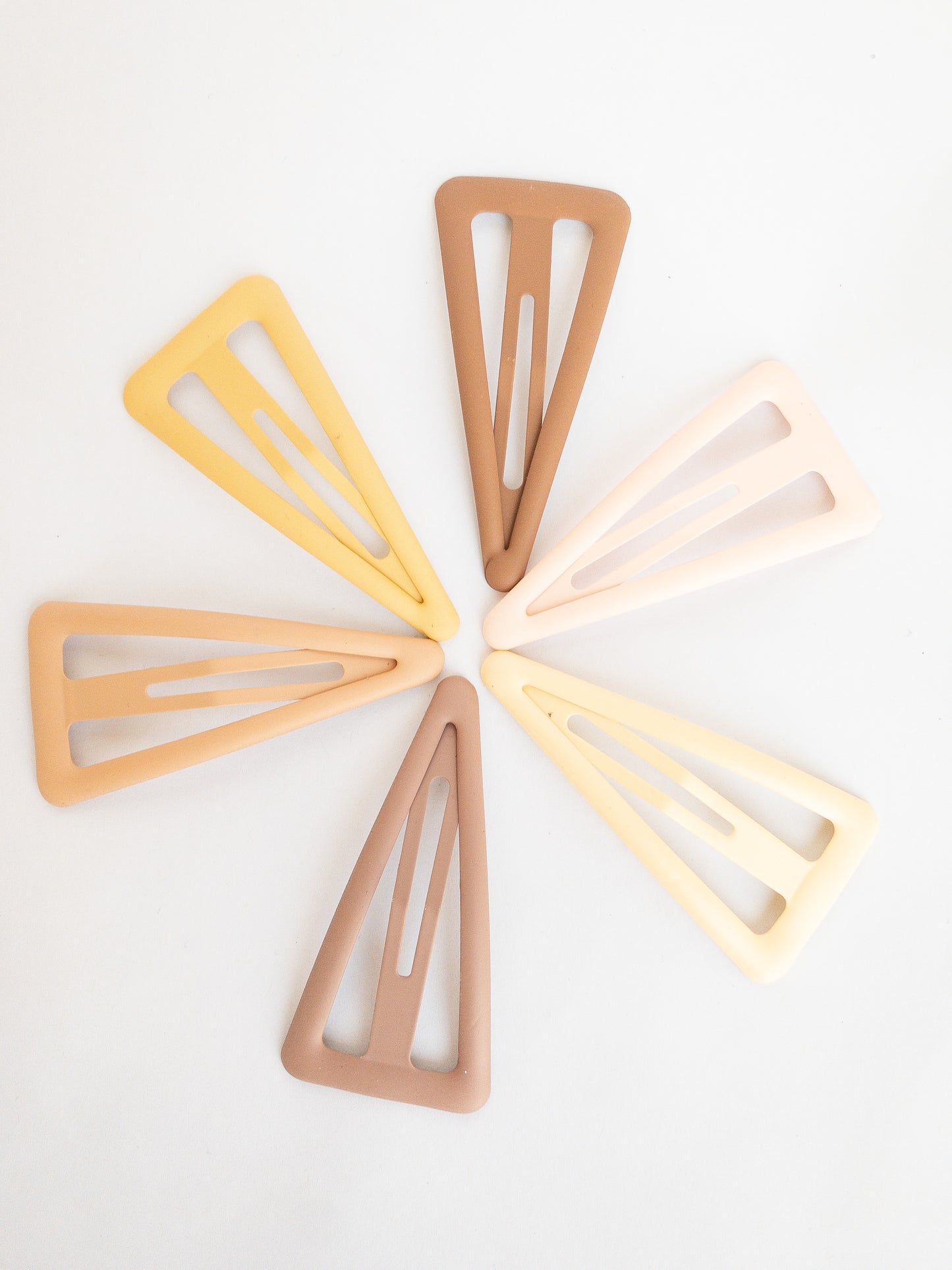 These large triangle snap clips are a fan favorite! With an ombre color palette fading from darker to lighter shades, you can mix them up and wear them together or choose your favorite of the day. Larger than your usual snap clip, these are sure to make a statement and hold your hair firm.