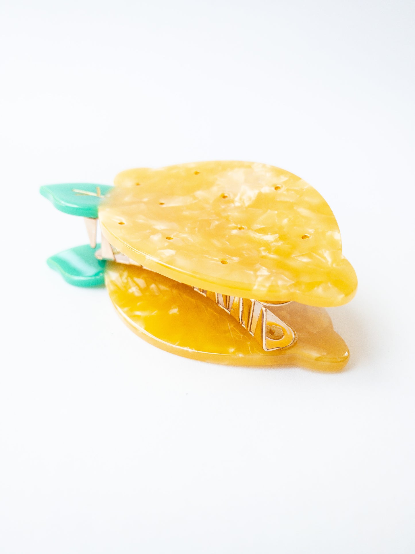 A happy yellow lemon hair claw with beautiful flecks, gold dimples, and a green leaf. Nothing brightens up your day like a sunny lemon! This hair claw clip is a medium size, great for half up hairstyles.
