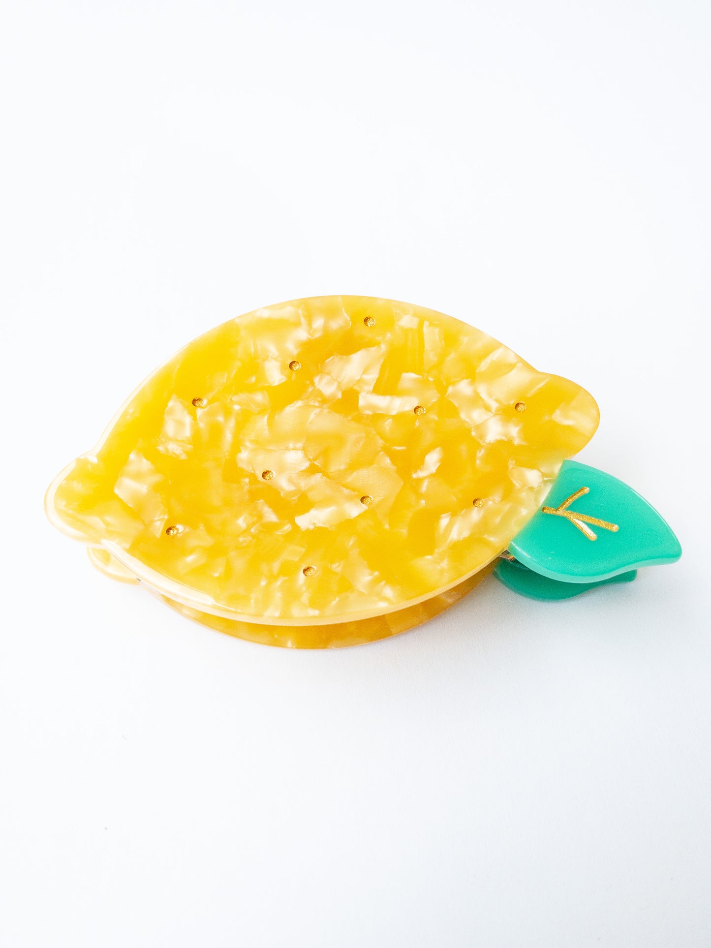 A happy yellow lemon hair claw with beautiful flecks, gold dimples, and a green leaf. Nothing brightens up your day like a sunny lemon! This hair claw clip is a medium size, great for half up hairstyles.