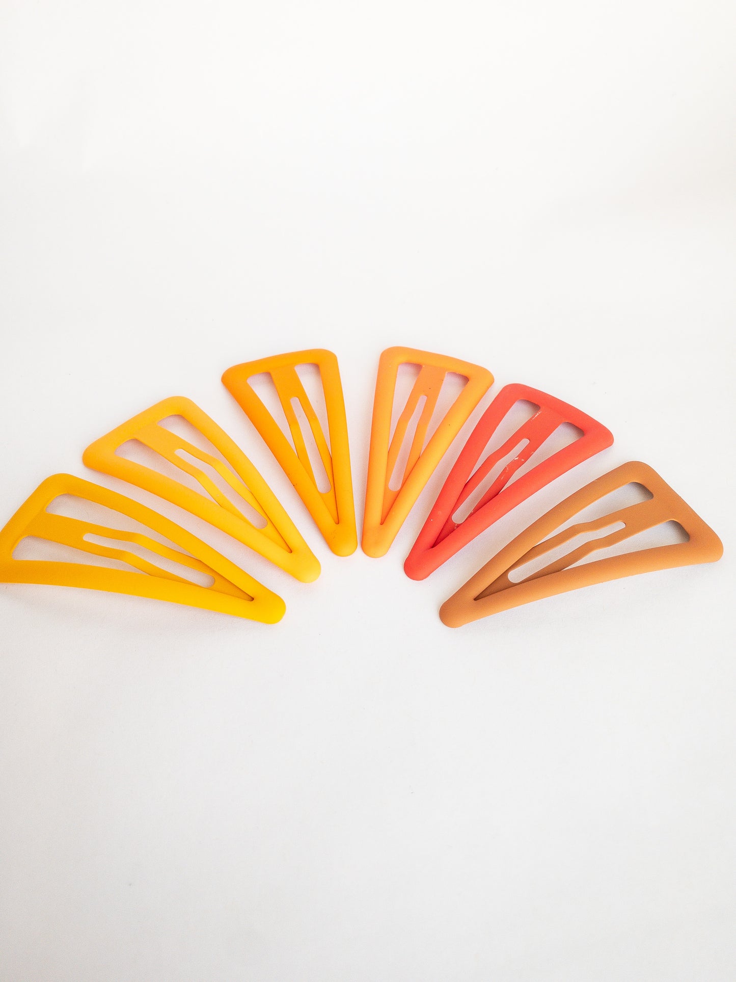 These large triangle snap clips are a fan favorite! With an ombre color palette fading from darker to lighter shades, you can mix them up and wear them together or choose your favorite of the day. Larger than your usual snap clip, these are sure to make a statement and hold your hair firm.