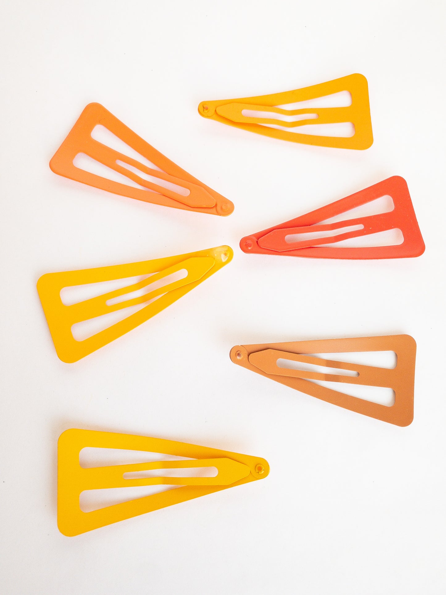 These large triangle snap clips are a fan favorite! With an ombre color palette fading from darker to lighter shades, you can mix them up and wear them together or choose your favorite of the day. Larger than your usual snap clip, these are sure to make a statement and hold your hair firm.