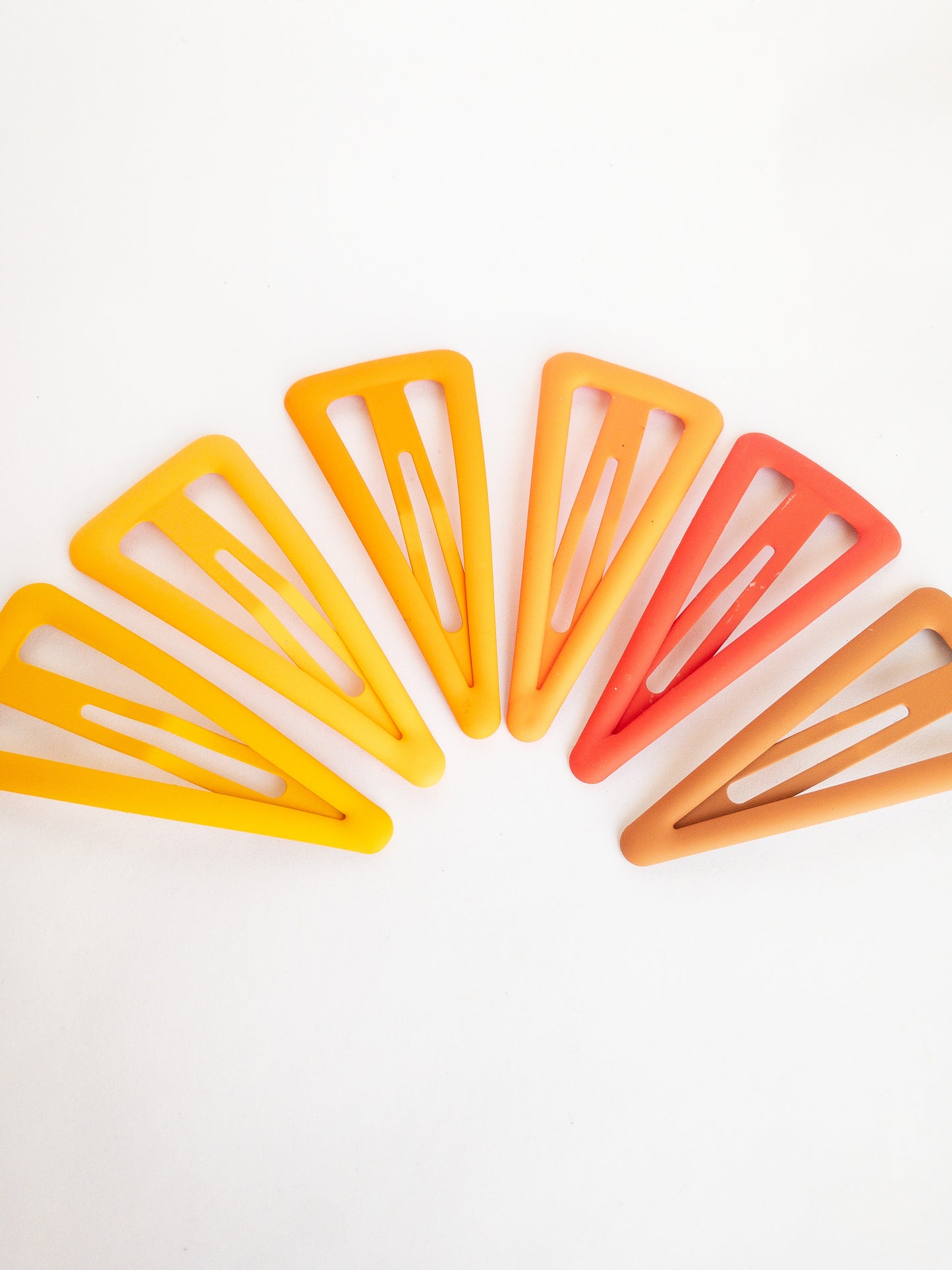 These large triangle snap clips are a fan favorite! With an ombre color palette fading from darker to lighter shades, you can mix them up and wear them together or choose your favorite of the day. Larger than your usual snap clip, these are sure to make a statement and hold your hair firm.
