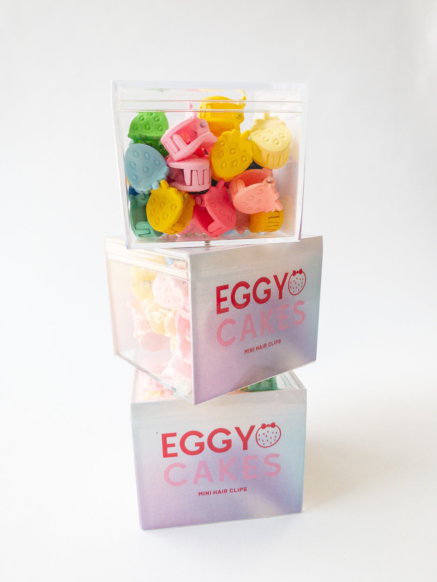 Nothing represents Eggy Cakes better than our signature mini strawberry hair clips! These adorable mini strawberries clipped through your hair look like a colorful strawberry patch and bring that extra bit of sweetness to any style. 36 sweet and dainty pieces in a variety of colors in our very own Eggy Cakes box, a perfect place to store them. Each hair clip is only half an inch in length. Have some fun with these in your own creative, fruity way. These really are a must have!