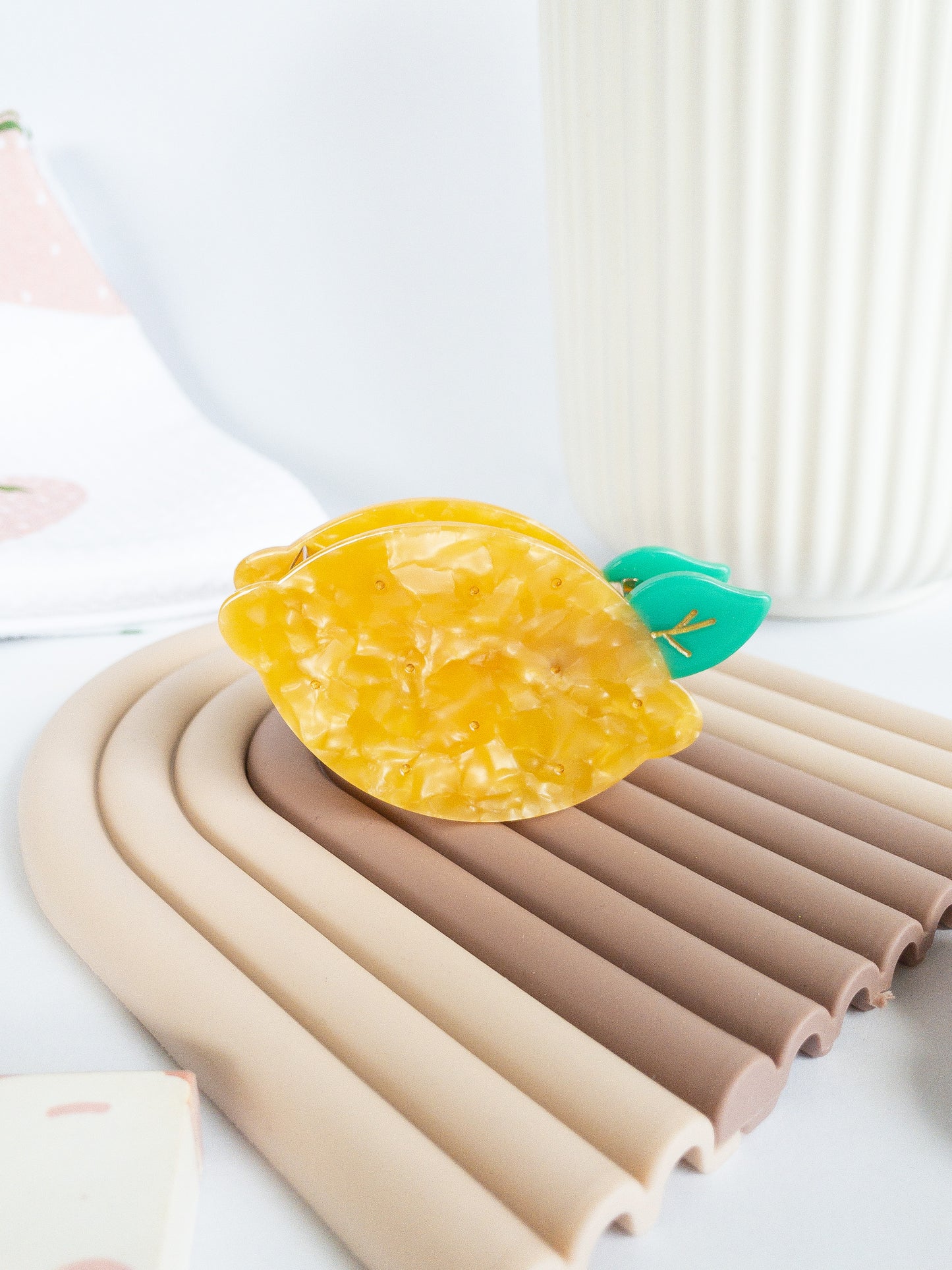 A happy yellow lemon hair claw with beautiful flecks, gold dimples, and a green leaf. Nothing brightens up your day like a sunny lemon! This hair claw clip is a medium size, great for half up hairstyles.