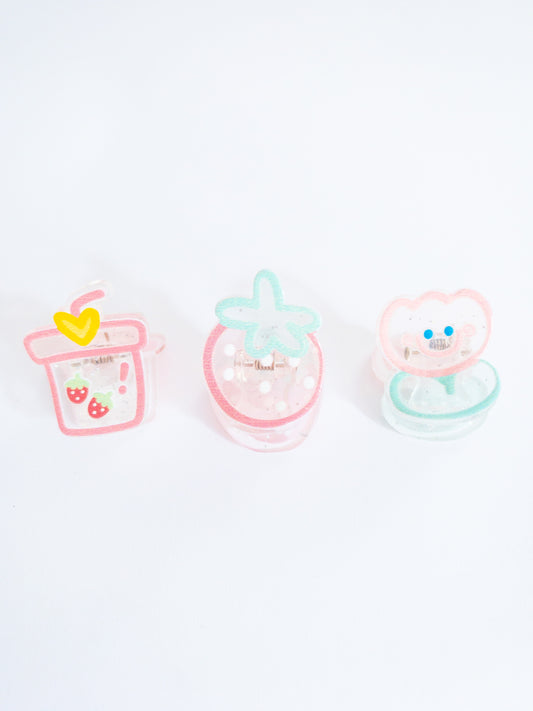 Just a happy tulip and her strawberry treats! A 3-pack of translucent, glittery small hair claws in the shape of a strawberry bubble tea, smiley tulip, and a juicy strawberry.