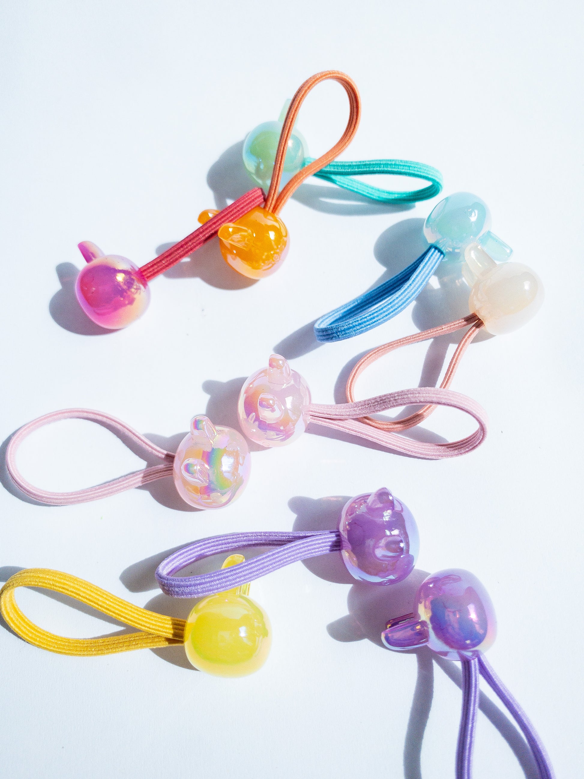Dreamy, iridescent bubble rabbit hair ties! These pearly hair ties glisten and gleam in candy taffy colors. They're strong enough to hold hairstyles and cute enough to wear them all at once. Each set contains 10 hair ties.