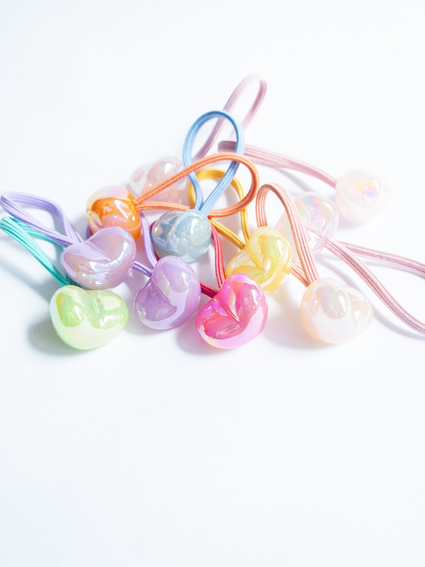Dreamy, iridescent bubble heart hair ties! These pearly hair ties glisten and gleam in candy taffy colors. They're strong enough to hold hairstyles and cute enough to wear them all at once. Each set contains 10 hair ties.