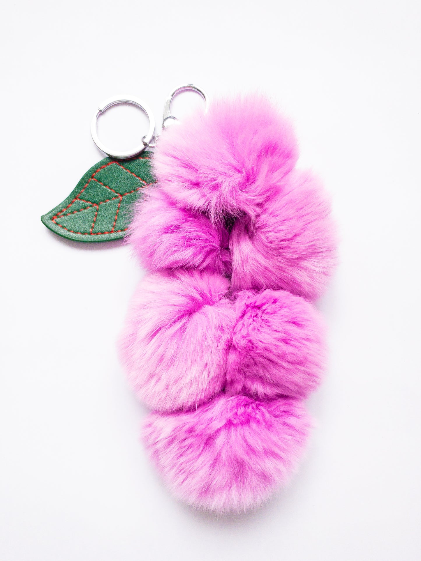 Add a pop of fun to your keys with this super soft grape keychain! The faux rabbit fur is addictively soft and strung together on a chain with a vegan leather grape petal. Clip onto your purse or backpack or attach your keys, making them easy to find at the bottom of your bag.
