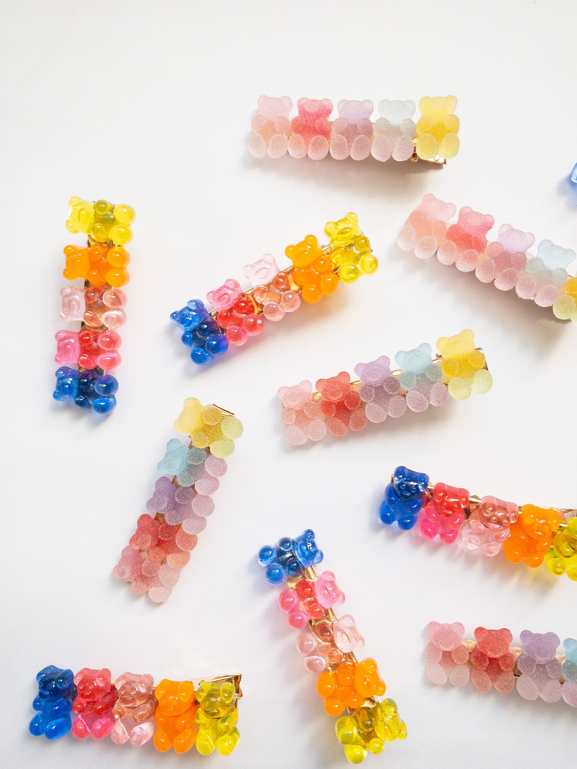 Yummy gummy bear family! The most adorable gummy bear shaped hair clips come as a 4 piece set: two frosted, sugary gummy bears and two translucent rainbow colored gummy bears. Each is on a gold colored alligator clip. 