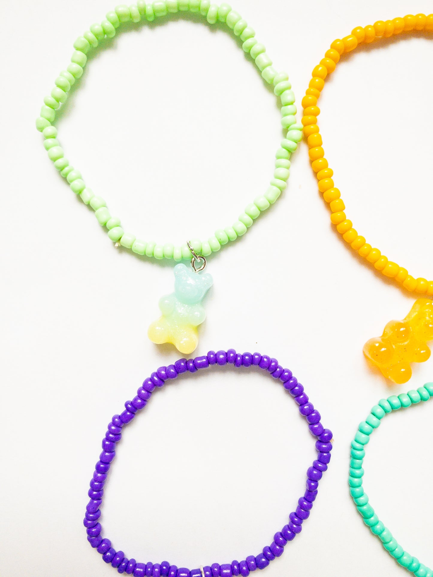A delectable set of 6 ombre and glittery gummy bear charms on colorful stretchy beaded bracelets. 