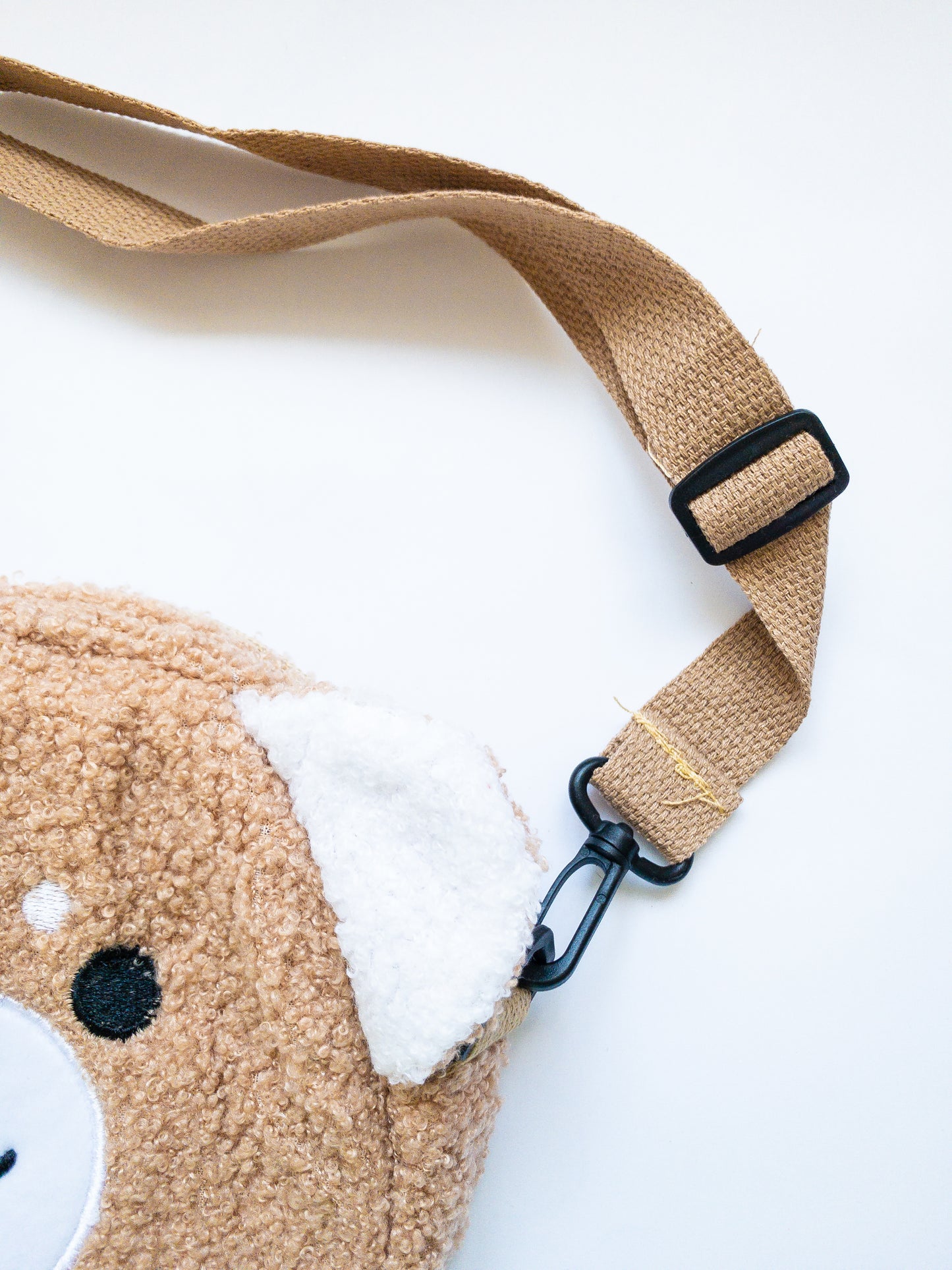This soft, sherpa, fuzzy happy faced Shiba Inu bag is just the cutest! Fabric strap is adjustable and removable. One zip open to a single compartment purse. Great length and size for kids! 