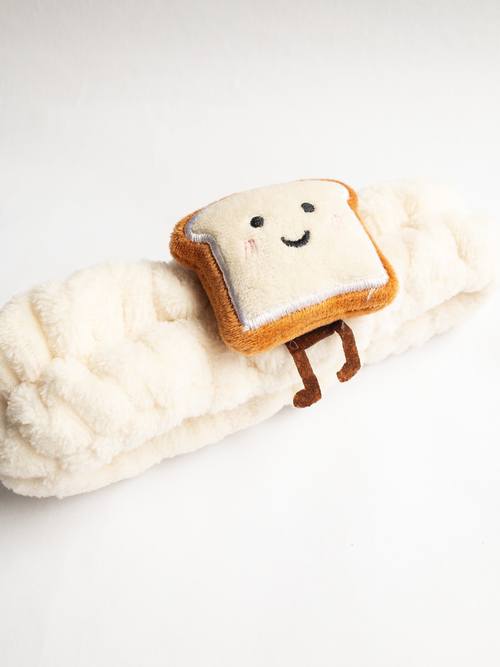 Our adorable brick toast plush spa headband makes the perfect accessory for all your spa days! Each headband is so soft and comfy with a cute and happy little brick toast. Pamper yourself in plushy-goodness and sweet, sweet relaxation! Go ahead, you deserve it!