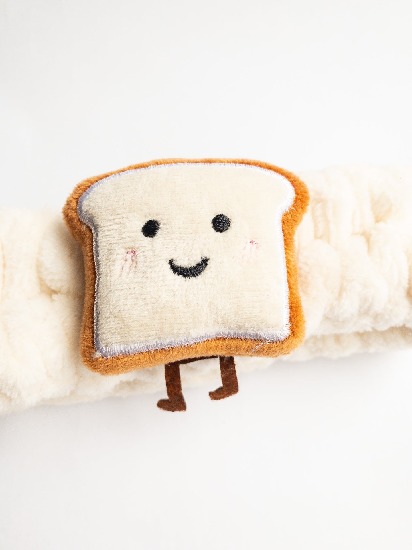 Our adorable brick toast plush spa headband makes the perfect accessory for all your spa days! Each headband is so soft and comfy with a cute and happy little brick toast. Pamper yourself in plushy-goodness and sweet, sweet relaxation! Go ahead, you deserve it!