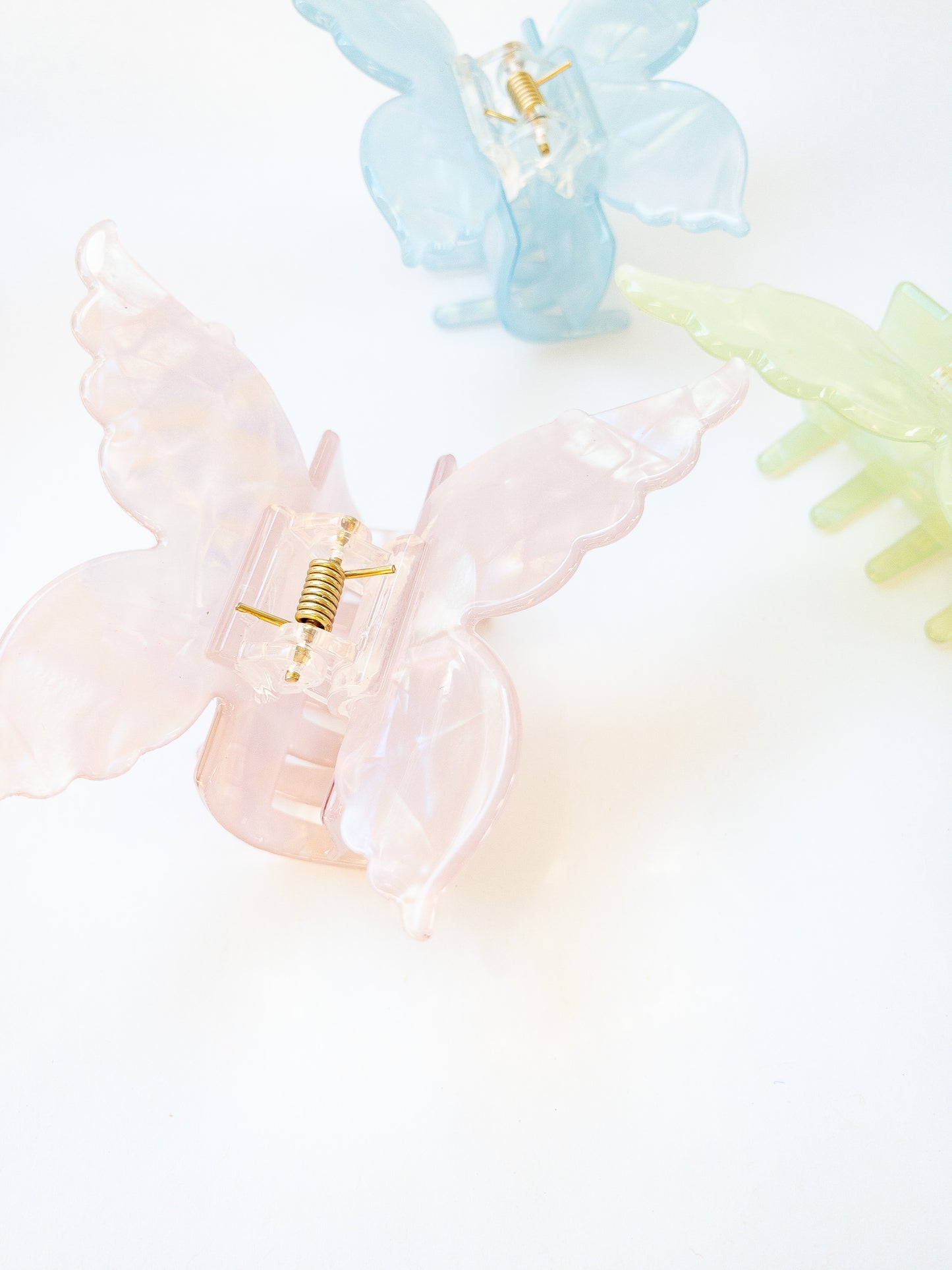 A shimmery, opalescent charm pink butterfly hair claw that glimmers in the light. This medium hair claw has detailed butterfly wings and has beautiful flecks of blue, green and yellow throughout. A gorgeous hair claw clip!
