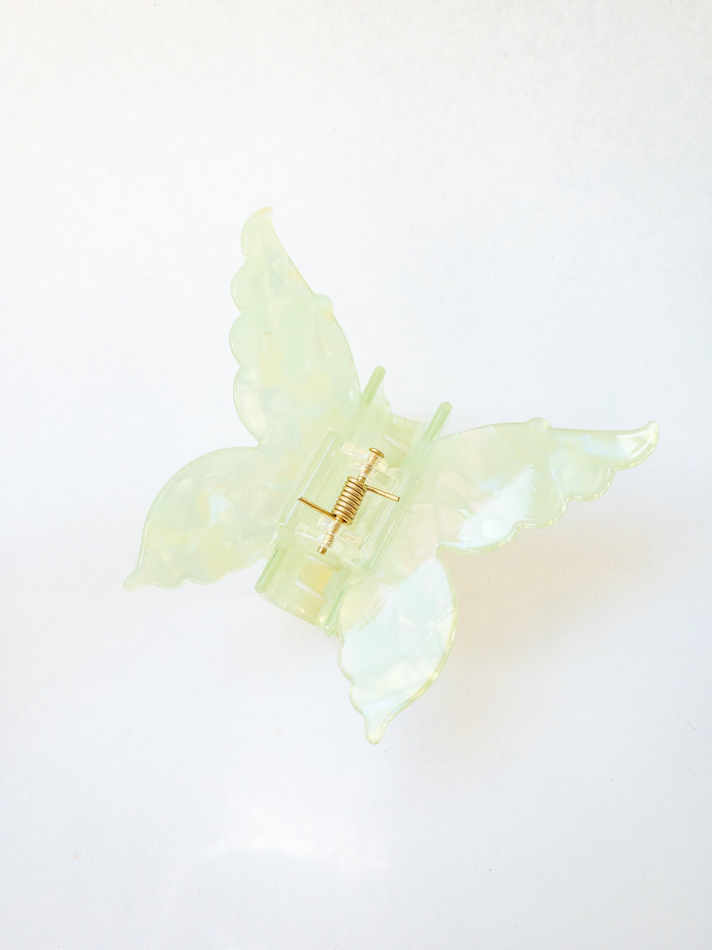 A shimmery, opalescent emerald green butterfly hair claw that glimmers in the light. This medium hair claw has detailed butterfly wings and has beautiful flecks of blue, pink and yellow throughout. A gorgeous hair claw clip!