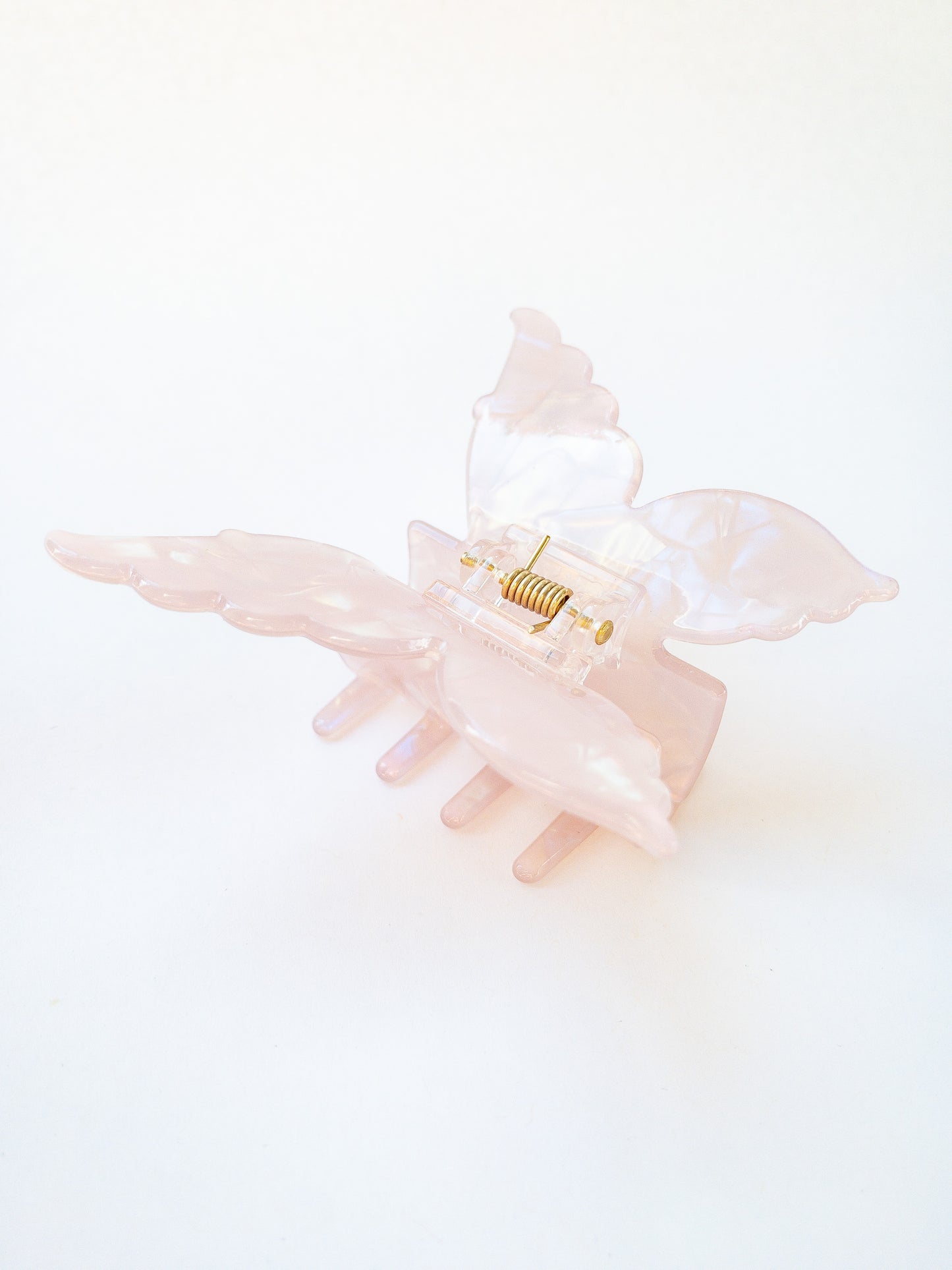 A shimmery, opalescent charm pink butterfly hair claw that glimmers in the light. This medium hair claw has detailed butterfly wings and has beautiful flecks of blue, green and yellow throughout. A gorgeous hair claw clip!