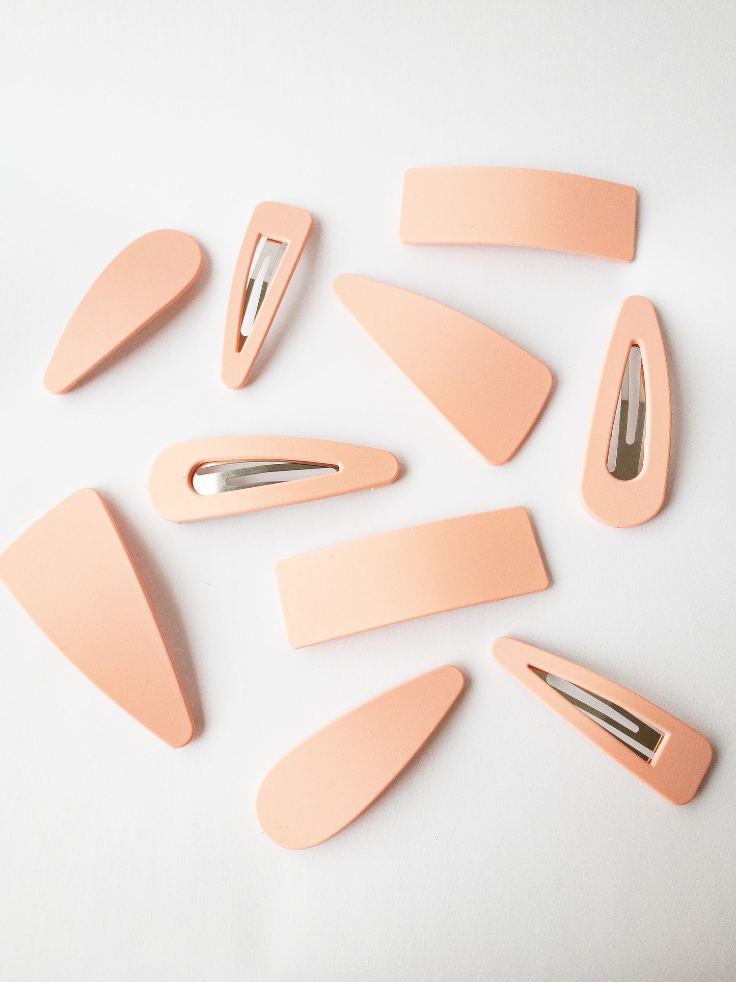The very best of a classic hair clip! These large snap clip barrettes are your everyday go to and come in a variety of shapes. There are two of each: asymmetrical triangle, triangle outline, solid teardrop, teardrop outline, and solid rectangle. Each set comes in an easy to store box and the matte colors are a must have!
