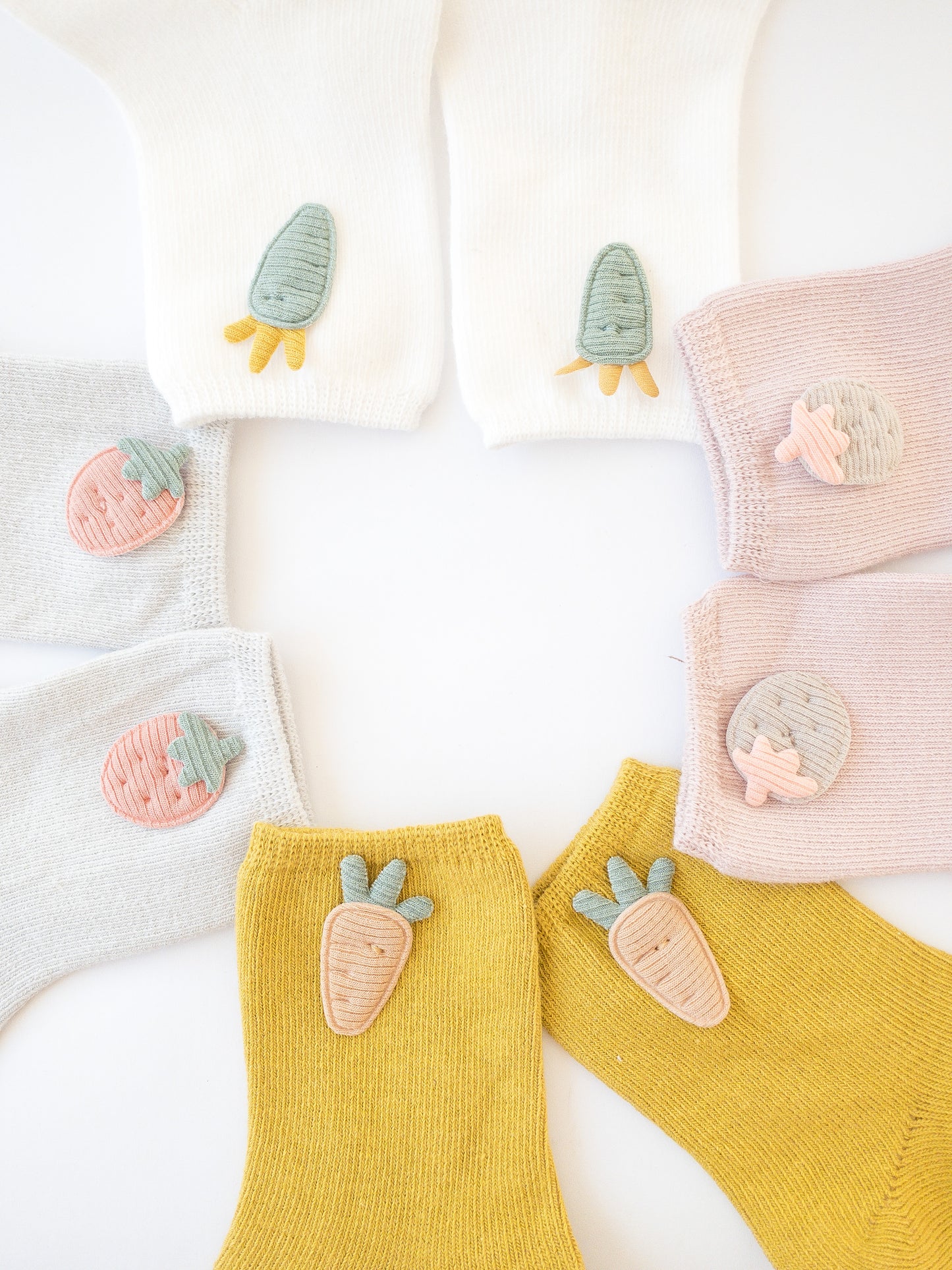 Our love for fruit continues with these socks adorned with cute fabric strawberries and carrots. Each set comes with 4 pairs of socks. Choose from two colorways: pink/yellow/grey/white or blue/grey/taupe/white.