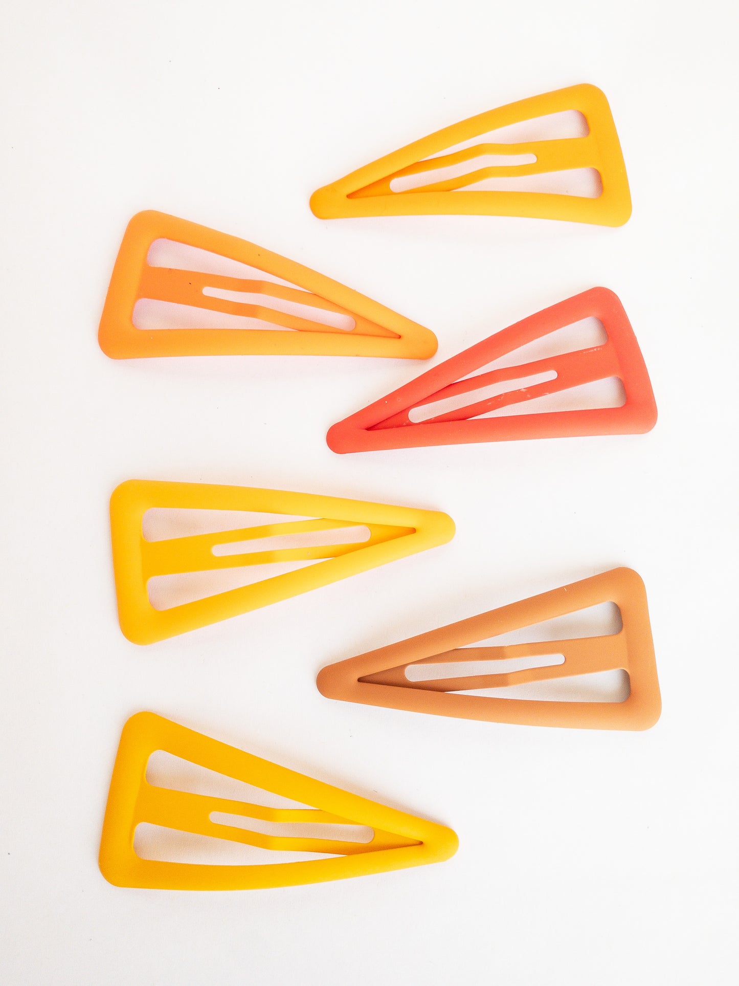 These large triangle snap clips are a fan favorite! With an ombre color palette fading from darker to lighter shades, you can mix them up and wear them together or choose your favorite of the day. Larger than your usual snap clip, these are sure to make a statement and hold your hair firm.