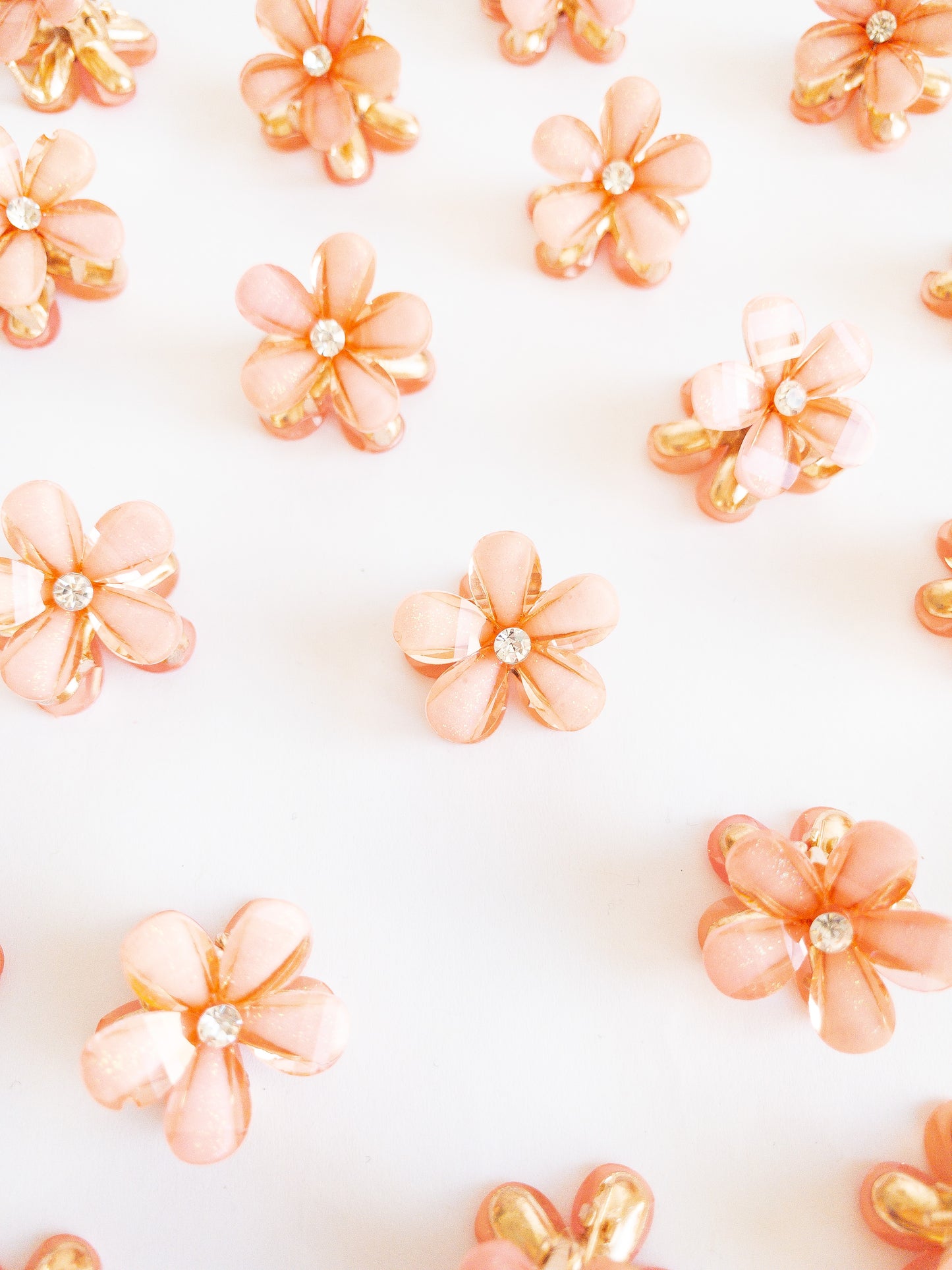 Dazzling small flower hair claws with a subtle glittery shimmer and a pretty white gemstone in the center. Each set has two flower claws to pair up in your favorite styles.