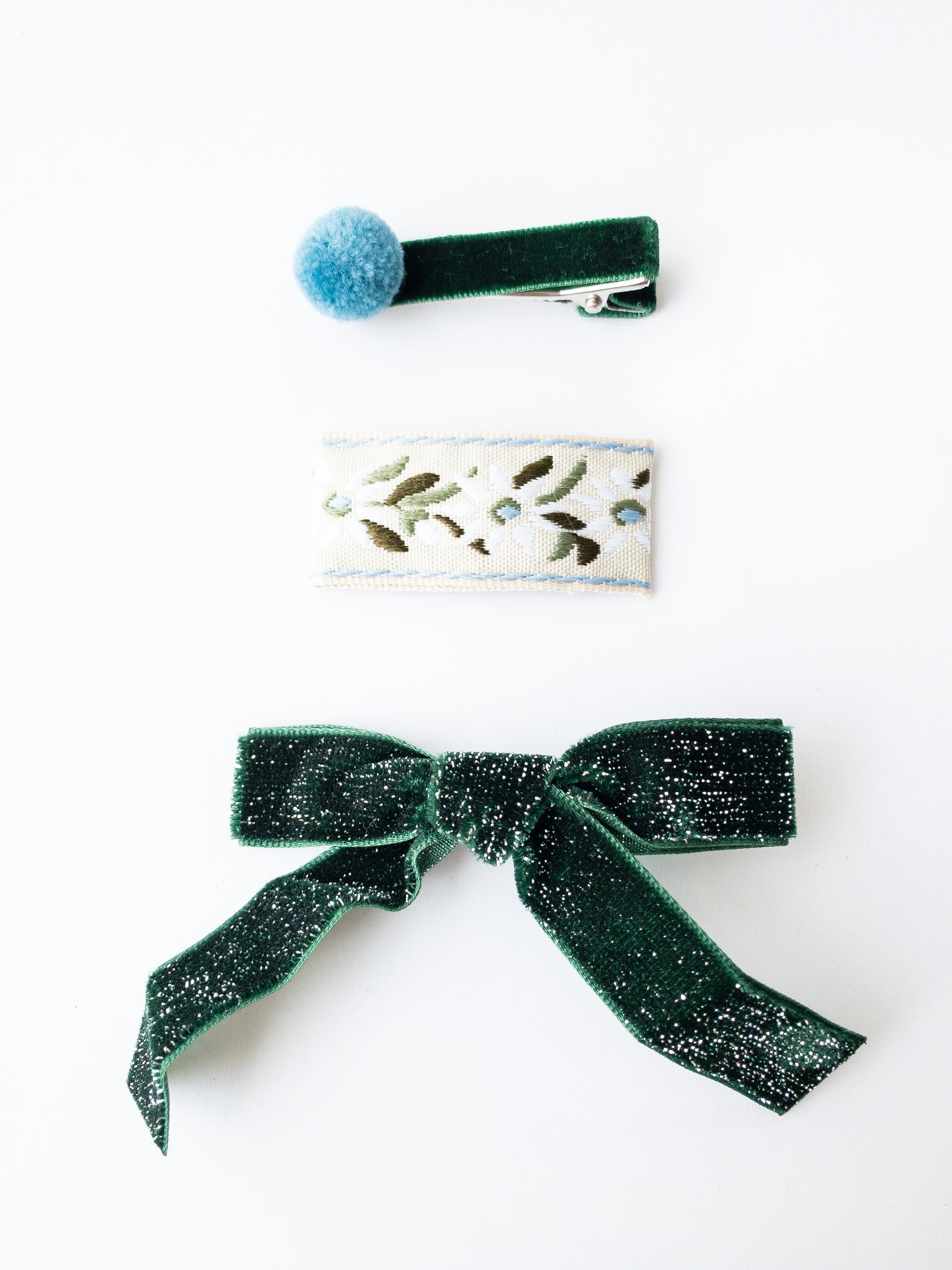 Festive and sparkly, this velvet bow is a classic for any occasion. It comes with a floral fabric wrapped snap clip and a darling velvet pom pom hair clip. Choose from 4 beautiful shades. 