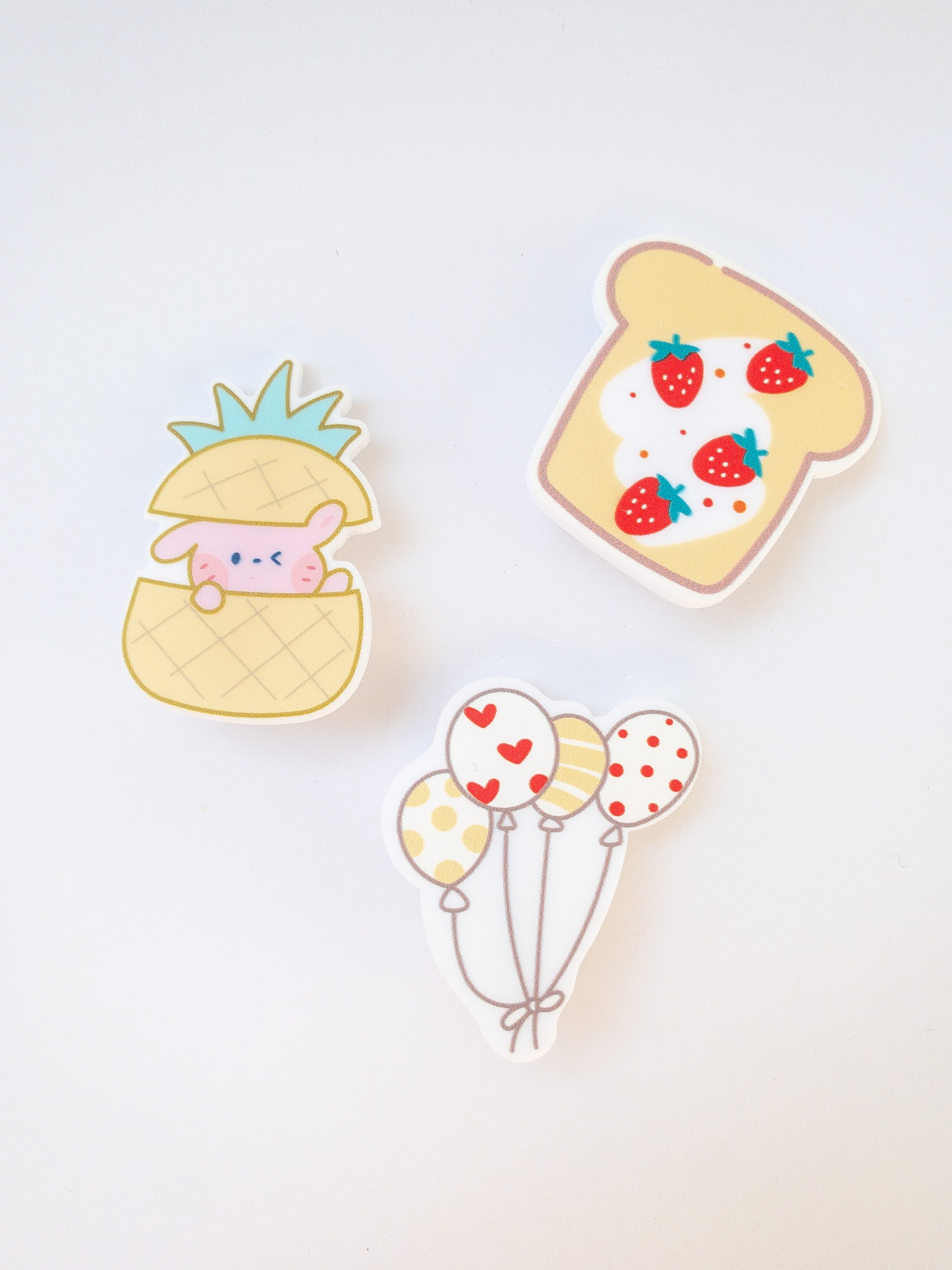 A set of 3 yellow hair clips in the sweetest shapes. A little pink bunny hidden inside a pineapple, a set of balloons, and a delicious strawberry toast.  Gold alligator clips
