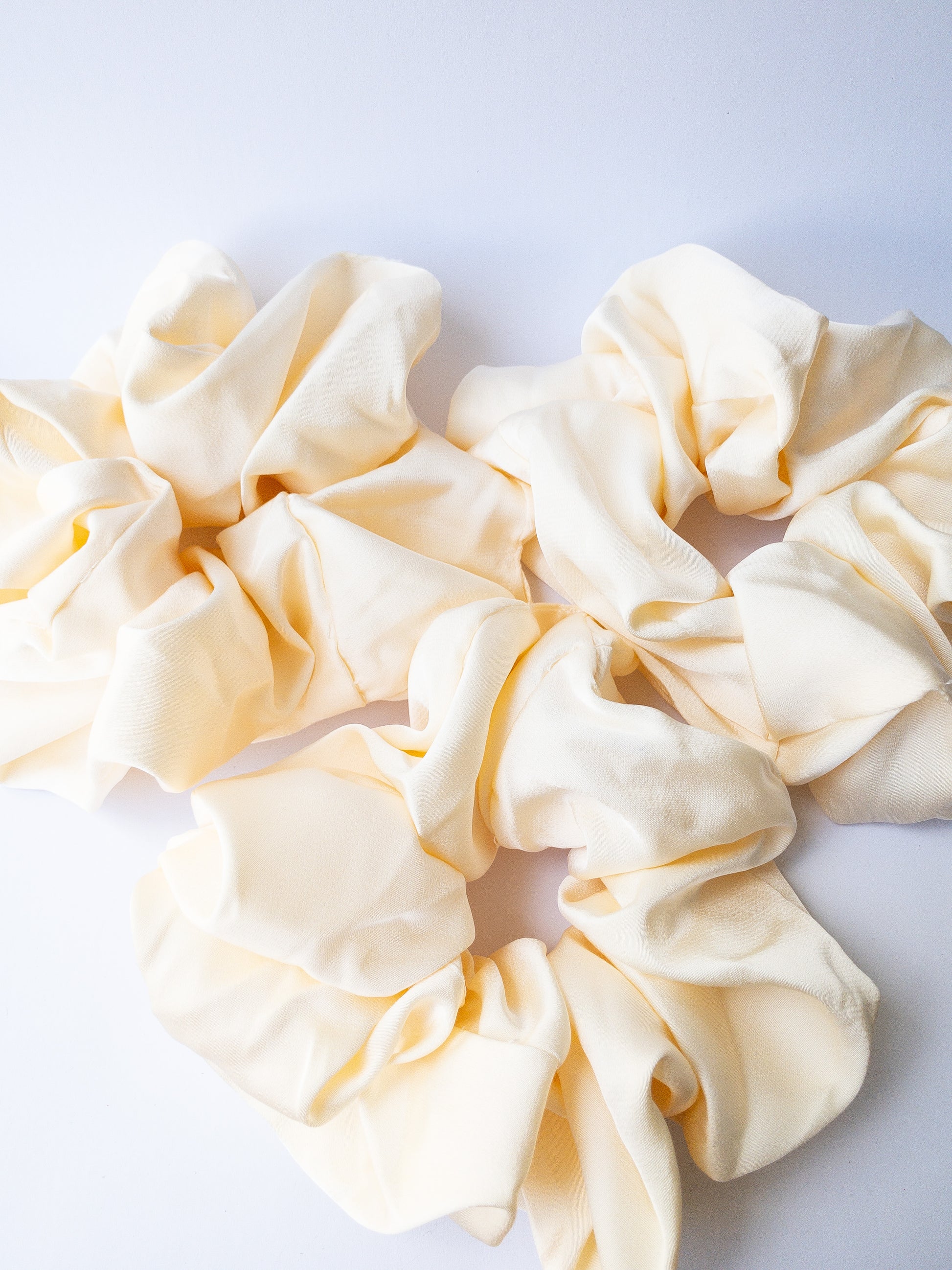 Rich and buttery soft jumbo oversized scrunchie in a beautiful ivory beige sheen. Perfect for holding curls and easily creating a romantic hairstyle. 