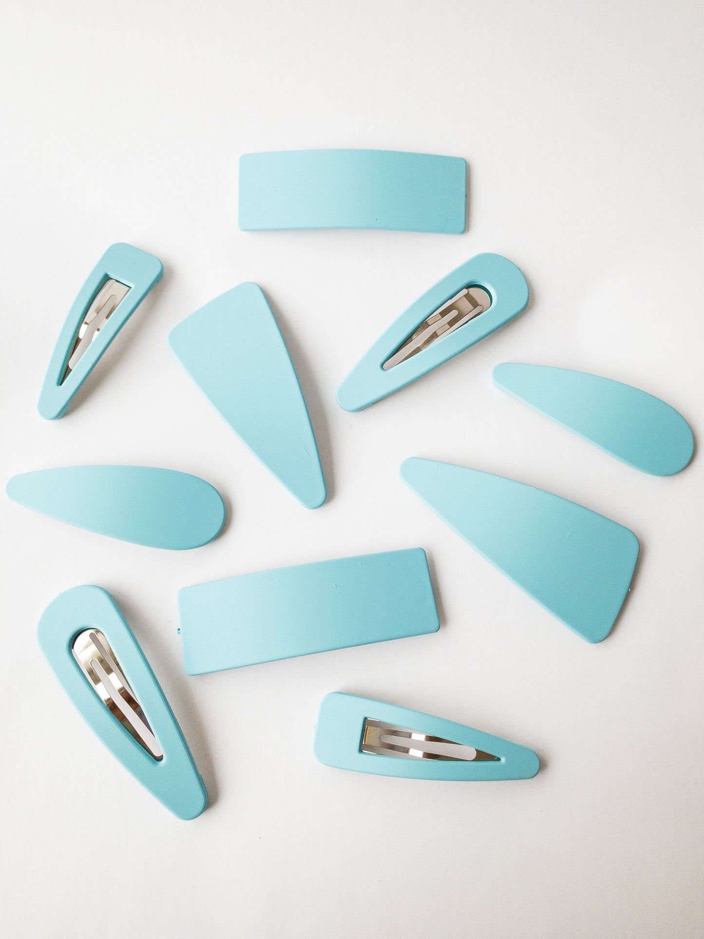 The very best of a classic hair clip! These large snap clip barrettes are your everyday go to and come in a variety of shapes. There are two of each: asymmetrical triangle, triangle outline, solid teardrop, teardrop outline, and solid rectangle. Each set comes in an easy to store box and the matte colors are a must have!