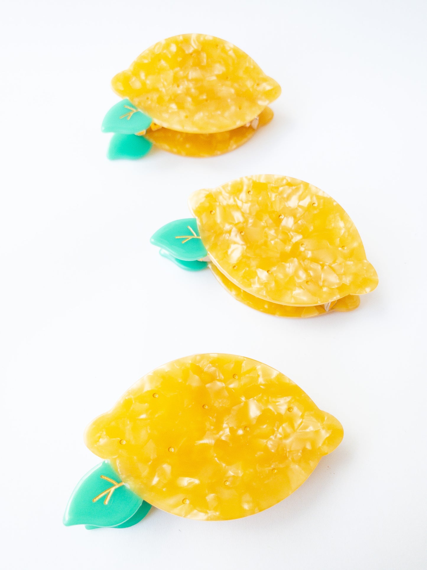 A happy yellow lemon hair claw with beautiful flecks, gold dimples, and a green leaf. Nothing brightens up your day like a sunny lemon! This hair claw clip is a medium size, great for half up hairstyles. 