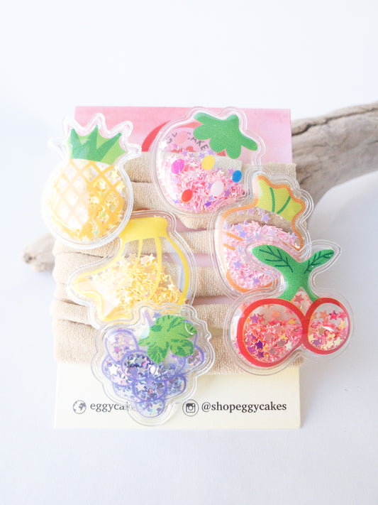 Our most popular shaker fruits now as baby bands! Six different cute fruits to choose from: strawberry, grapes, banana, carrot, cherry, and pineapple. Each shaker fruit is filled with tiny shimmery colorful star confetti. Make your own set, mix and match them!   Great for kids with little to no hair. The nylon elastic is super stretchy and super soft.