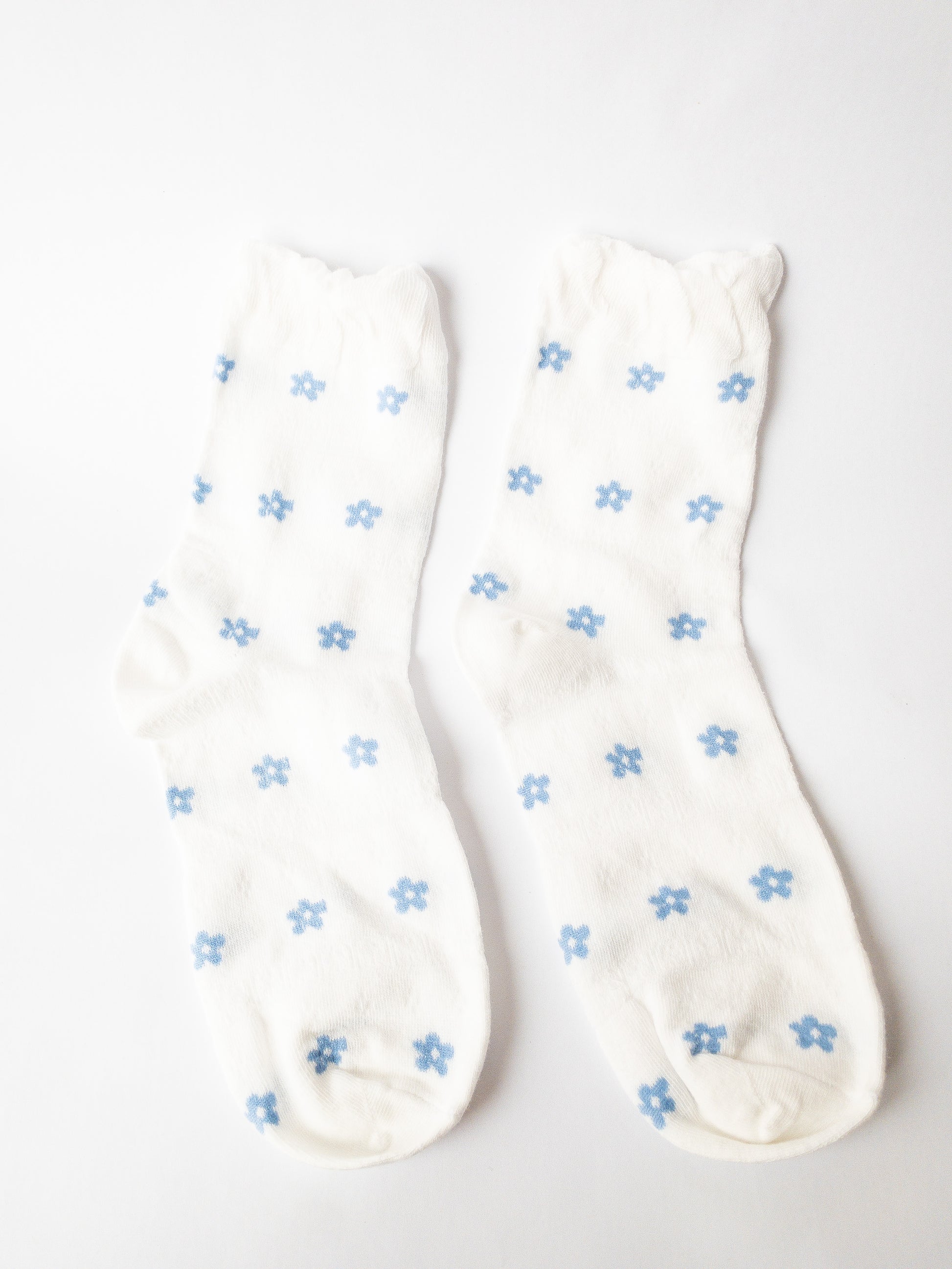 A soft floral socks set of 3 of the gentlest socks with tender ruffles. One pair is classic white and blue, one pair has delicate blue flowers throughout, and one pair is solid white with a sheer peekaboo floral lace.  Adult size 4-10, crew socks length.