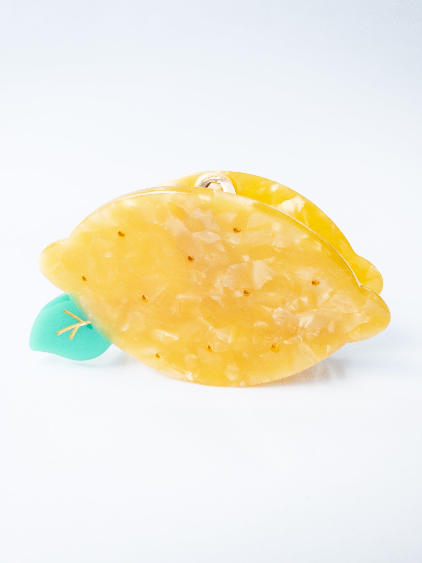 A happy yellow lemon hair claw with beautiful flecks, gold dimples, and a green leaf. Nothing brightens up your day like a sunny lemon! This hair claw clip is a medium size, great for half up hairstyles. 