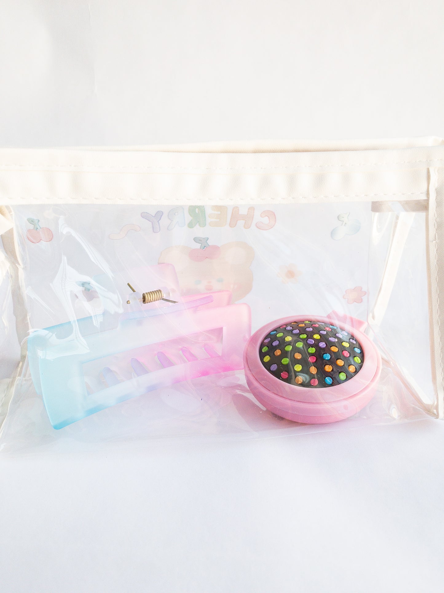 Have you wanted a storage pouch to take Eggy Cakes clips on the go? Here is the cutest little cherry bear pouch for just that! Use it to store your makeup, pencils, or hair clips. Clear pouch with an adorable bear, flower and cherries on one side.