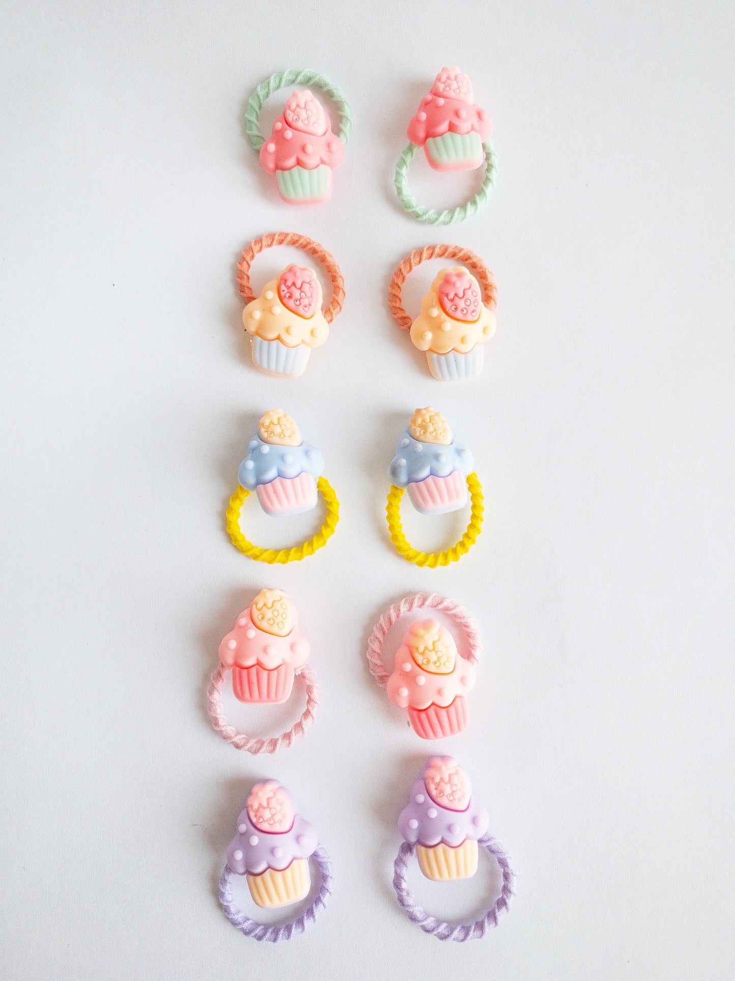 Candy colored little strawberry cupcake hair ties in sweet sets. These 10 hair ties come in pairs and are a great size for fun styles. The soft hair ties are gentle on hair and the sweetened mini cakes just give it that extra pop.