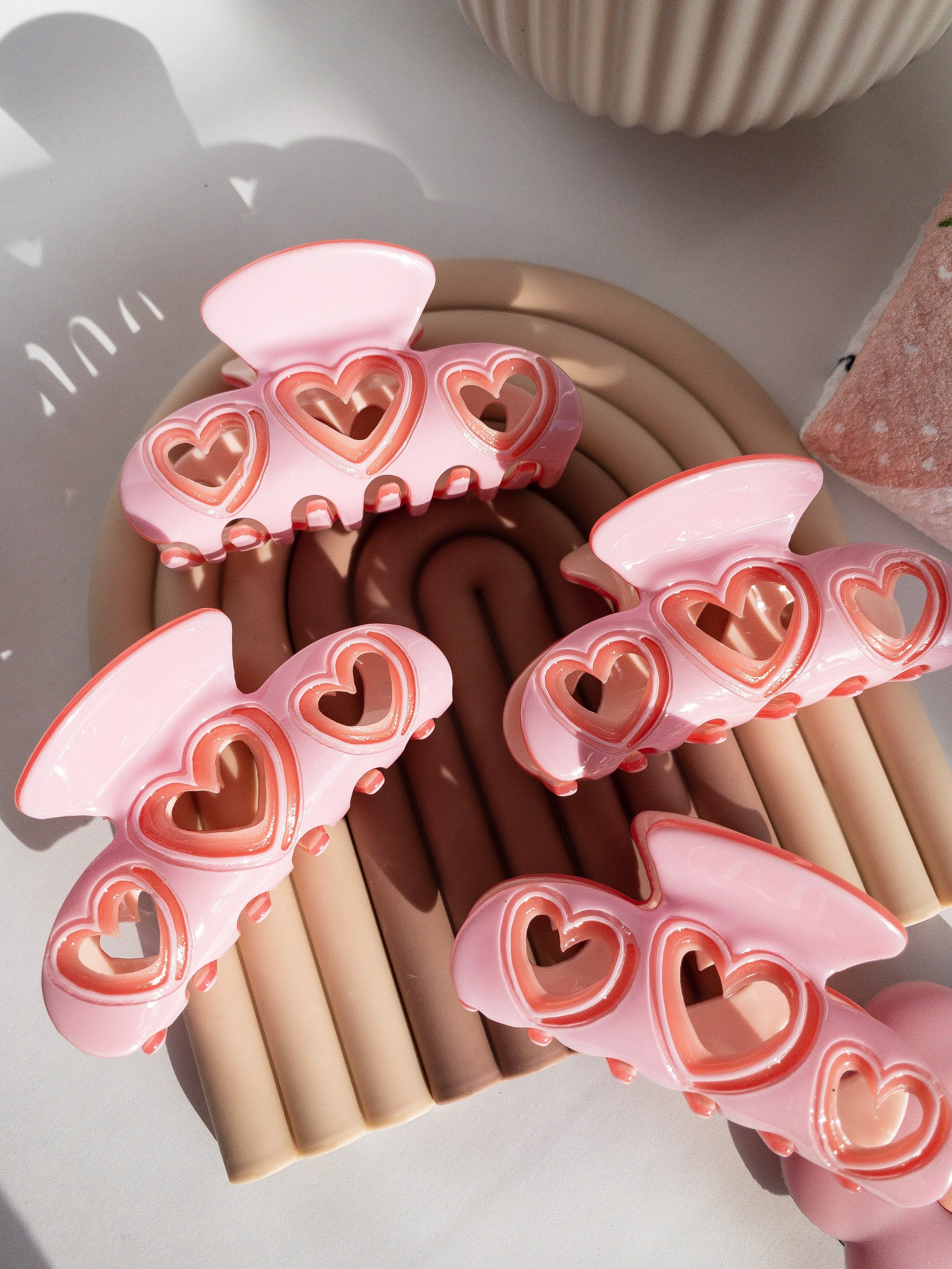 The hair claw clip for the sweethearts. The perfect medium size for half up hairstyles, strong and durable. Your hair is highlighted by the cut out hearts on each side. A beautiful sweet tart sugar pink color with a darker pink outline throughout. 