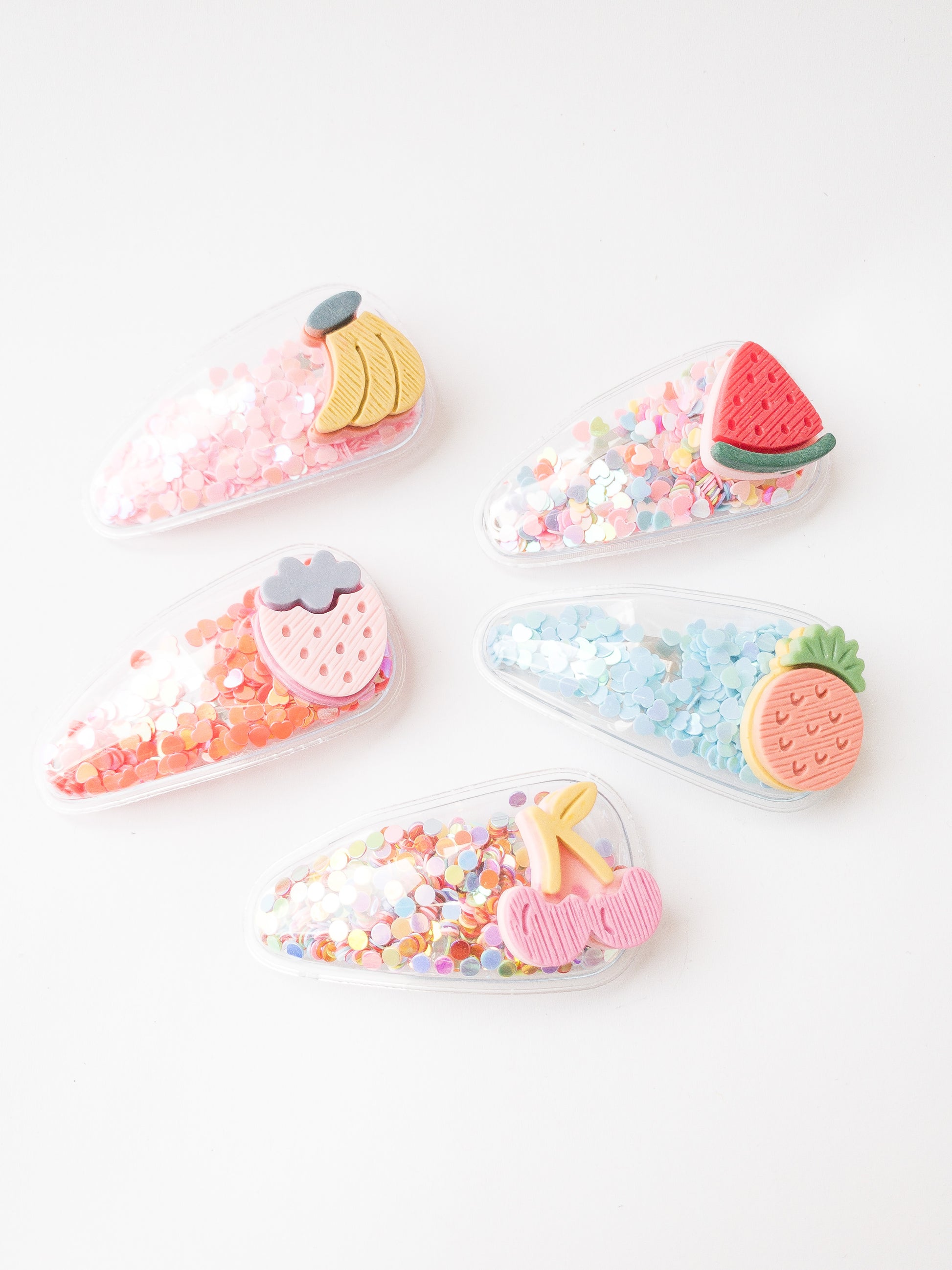 Our love of fruit continues with these transparent shaker clips filled with colorful confetti and a slice of fruit affixed to each. So fun to shake and snap on and off! This set has a banana, watermelon, strawberry, pineapple, and cherry.