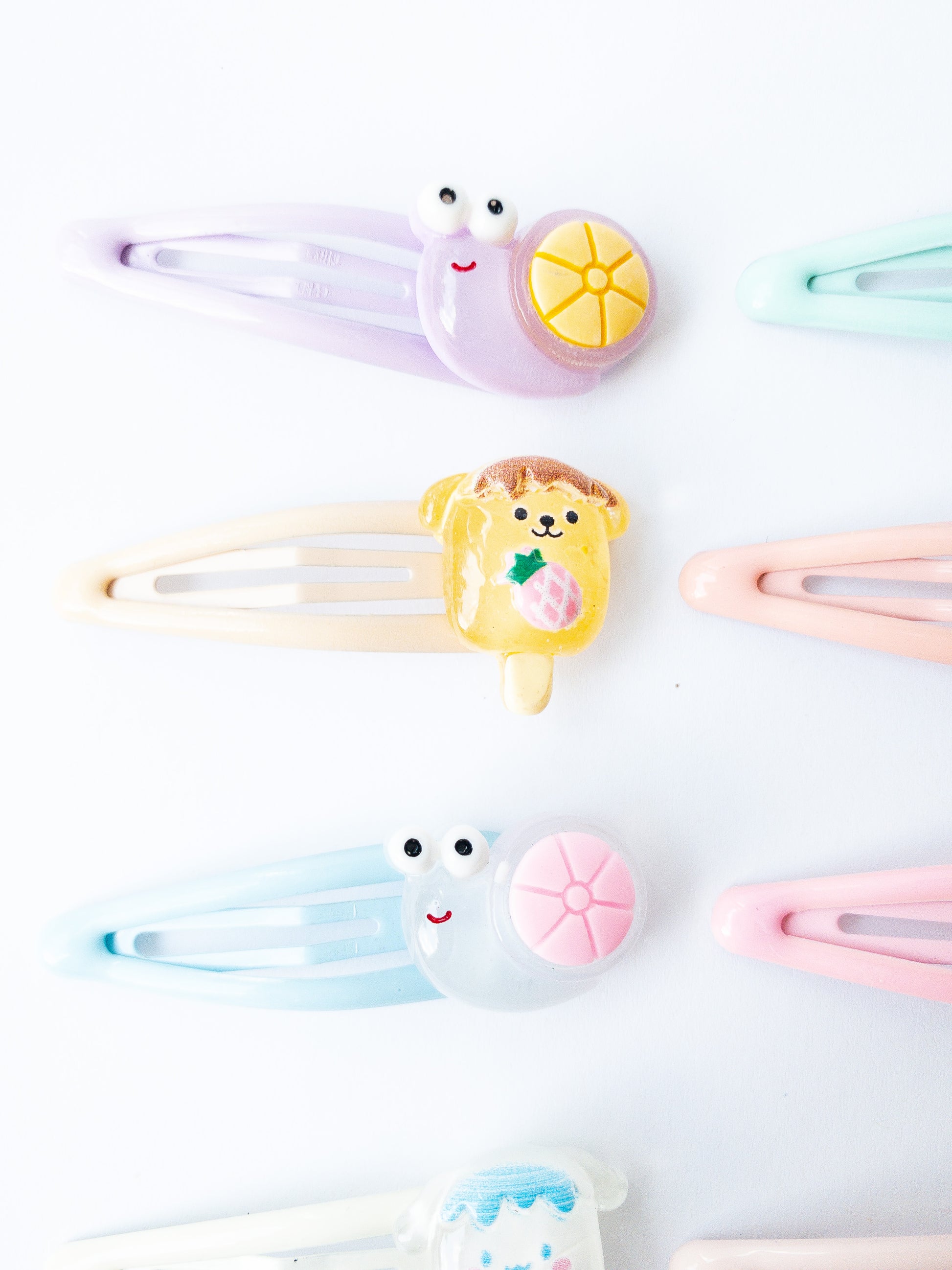 A set of 8 glossy pastel snap clips with some pretty cute characters! Four happy little snails and four fruity character popsicles. 