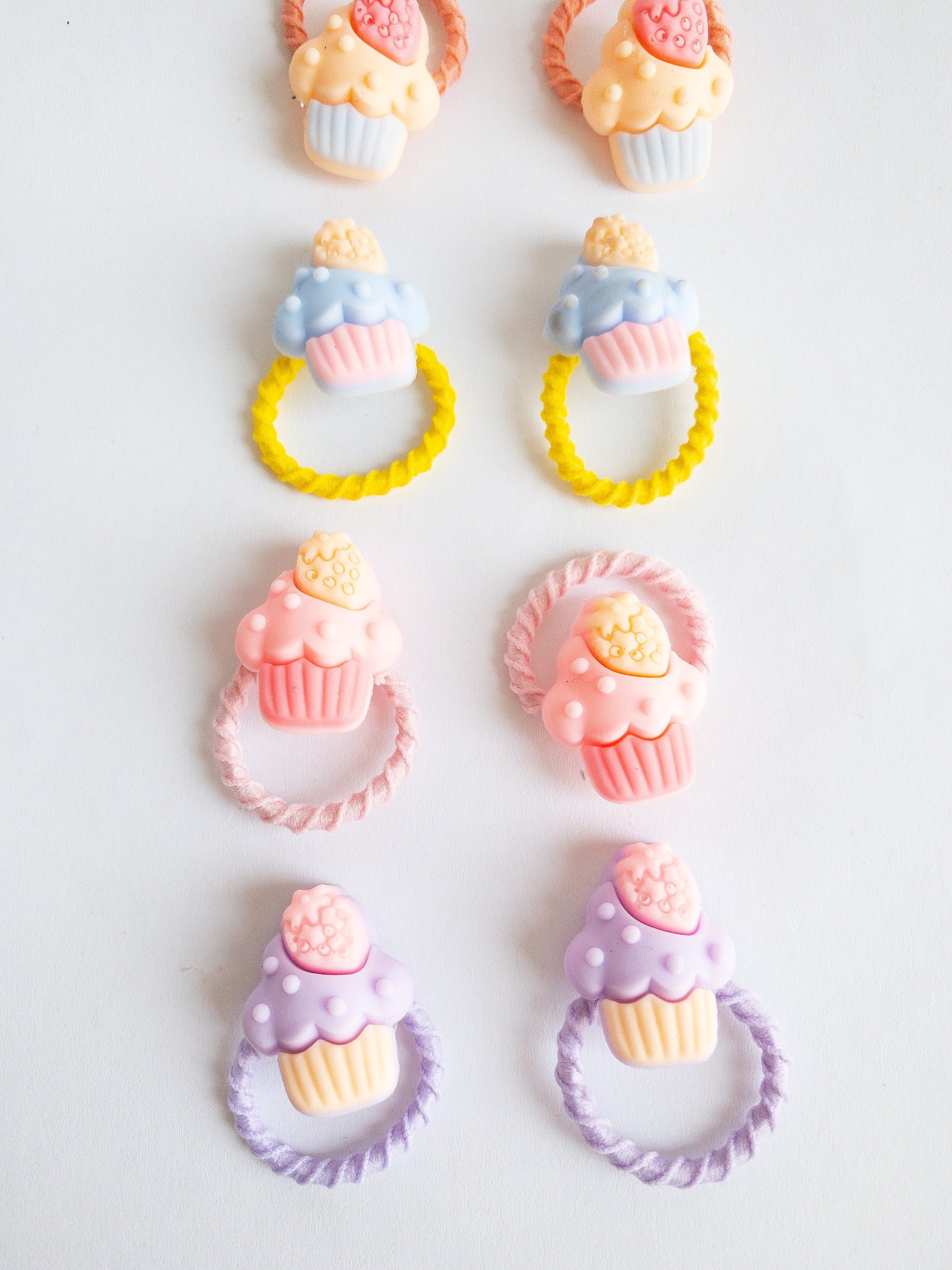 Candy colored little strawberry cupcake hair ties in sweet sets. These 10 hair ties come in pairs and are a great size for fun styles. The soft hair ties are gentle on hair and the sweetened mini cakes just give it that extra pop.
