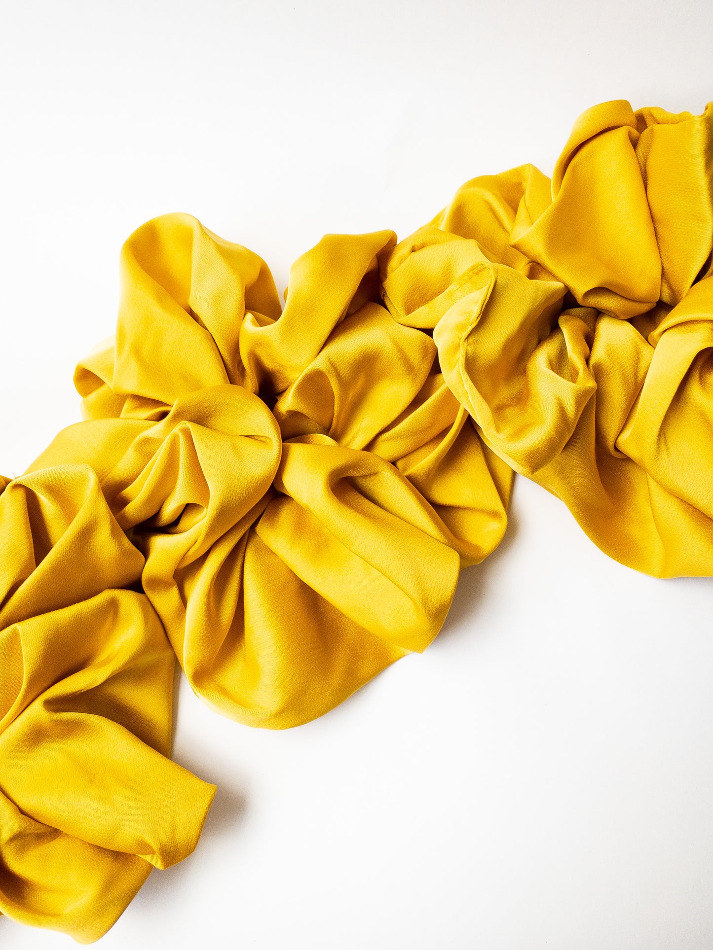 Rich and buttery soft jumbo oversized scrunchie in a beautiful turmeric yellow sheen. Perfect for holding curls and easily creating a romantic hairstyle. 