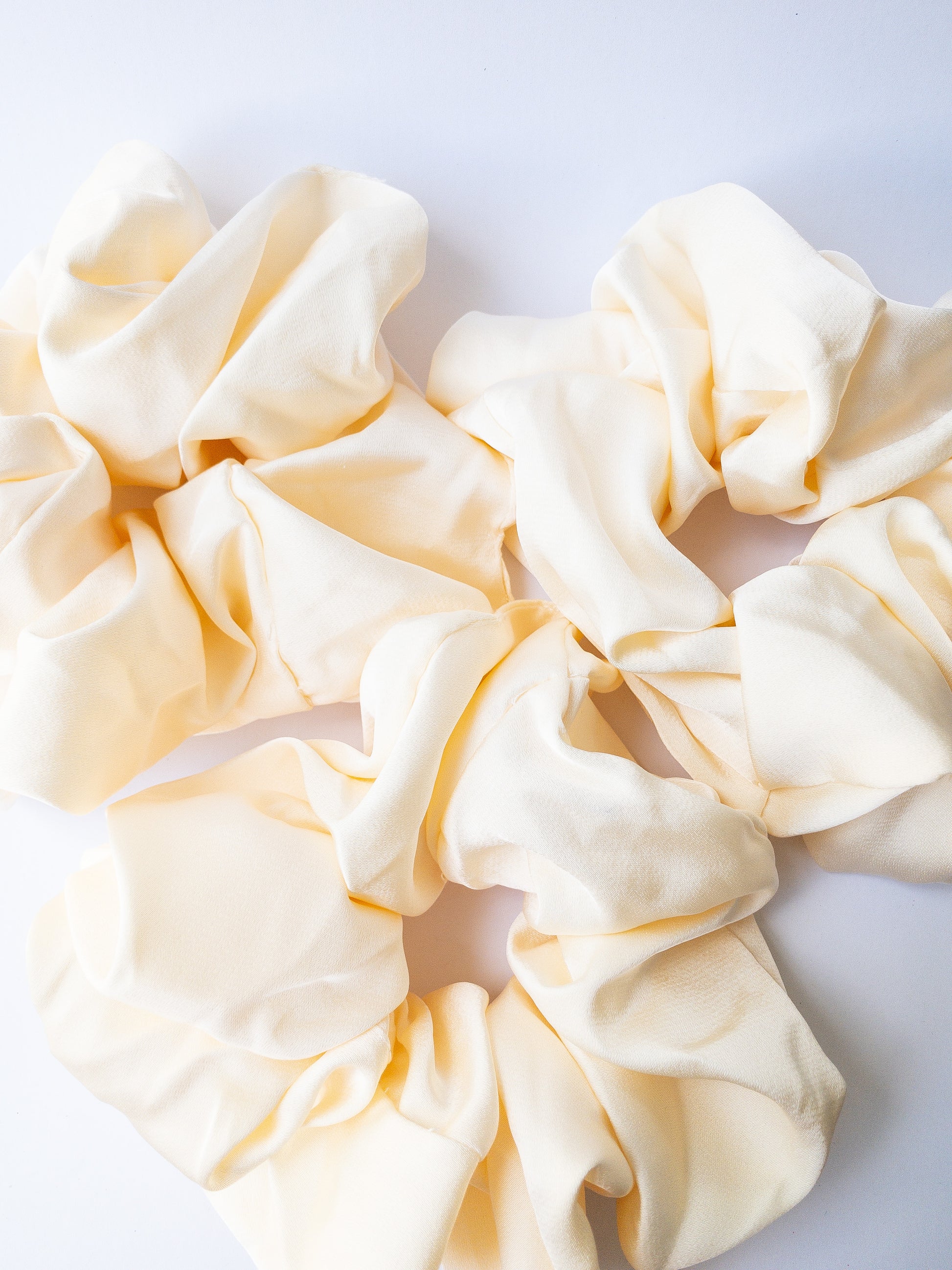 Rich and buttery soft jumbo oversized scrunchie in a beautiful ivory beige sheen. Perfect for holding curls and easily creating a romantic hairstyle. 