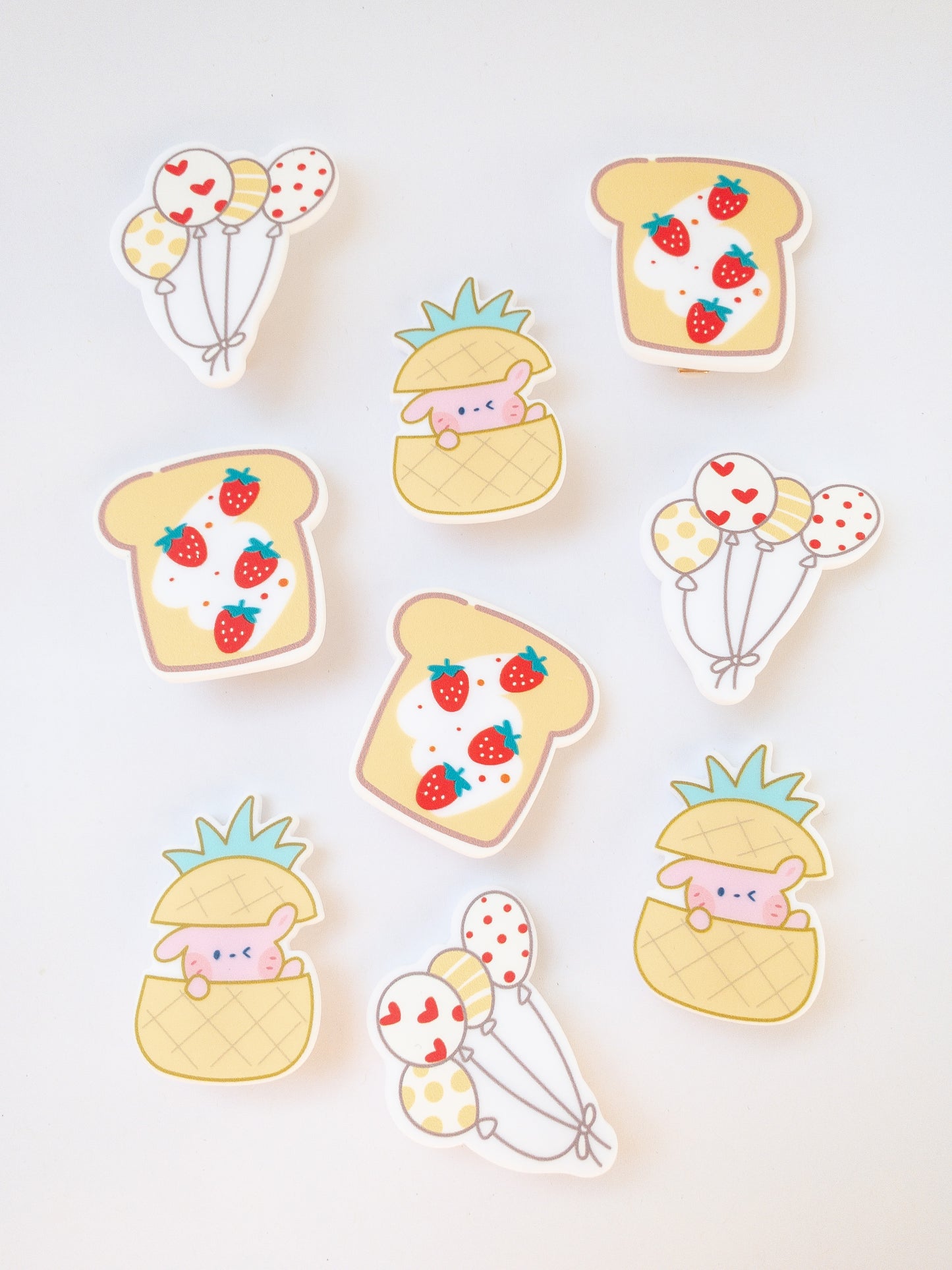 A set of 3 yellow hair clips in the sweetest shapes. A little pink bunny hidden inside a pineapple, a set of balloons, and a delicious strawberry toast.  Gold alligator clips